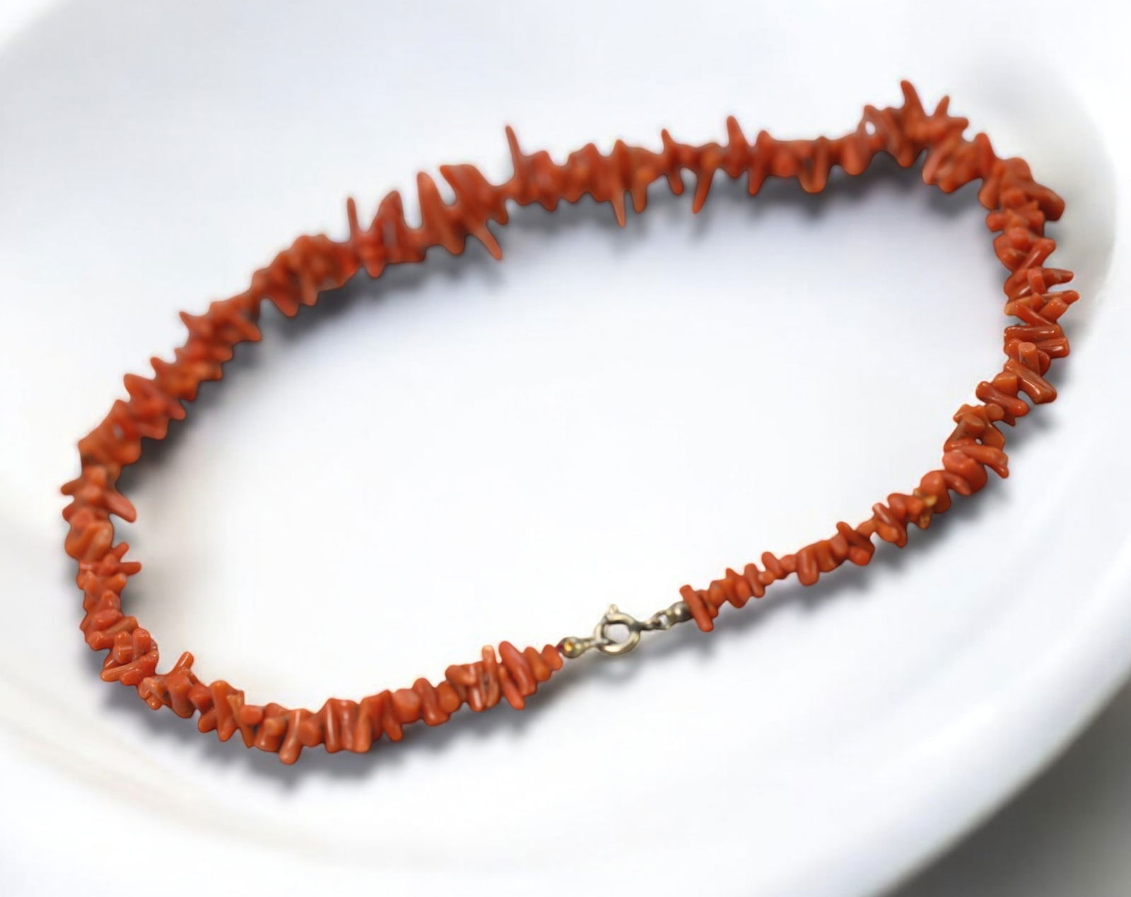 ITALY: Mediterranean Coral Necklace - Natural Branch Coral, Spring Clasp, Mid-20th Century: A vibrant strand of natural Mediterranean branch coral, measuring 21 x 2 cm and weighing 18g, strung with a classic gold-tone spring clasp. This necklace features dozens of irregularly shaped coral fr