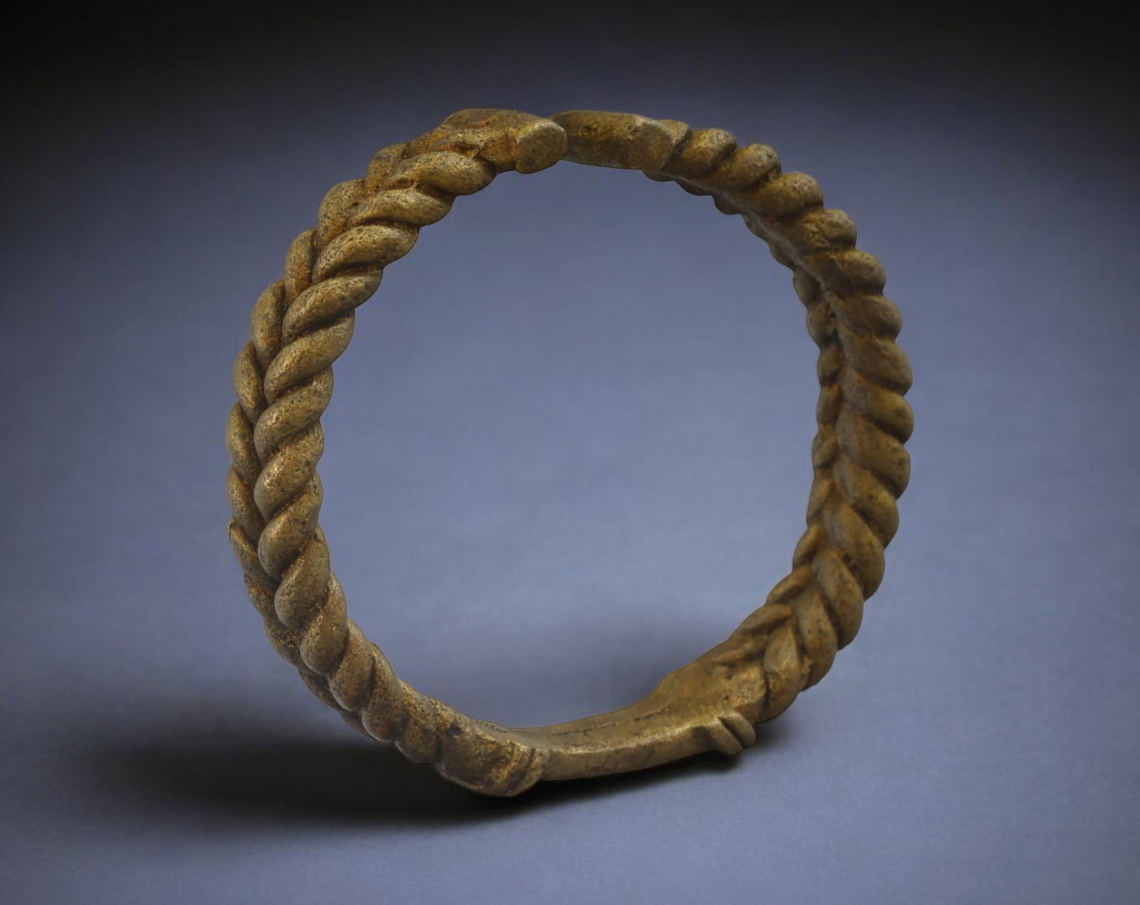 WEST AFRICA: Igbo Twisted Bronze Currency Bracelet - 19th-20th Century, 9cm, 162g: A remarkable Igbo bronze currency bracelet from Nigeria, measuring 9cm in diameter and weighing 162g. This piece showcases a finely crafted twisted rope design, a signature element of Igbo metalwork, 