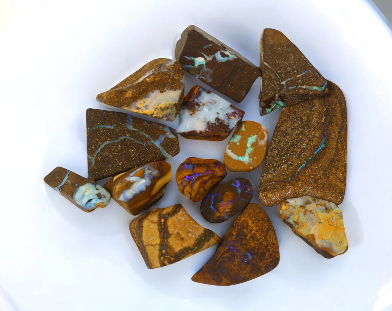 AUSTRALIAN MATRIX BOULDER OPAL - Rough Lot, 46g, 1-3.2cm (Images Taken Wet): A striking lot of natural Australian matrix boulder opal rough. These raw specimens display mesmerizing flashes of blue, green, and gold veins running through ironstone, characteristic of high-quality