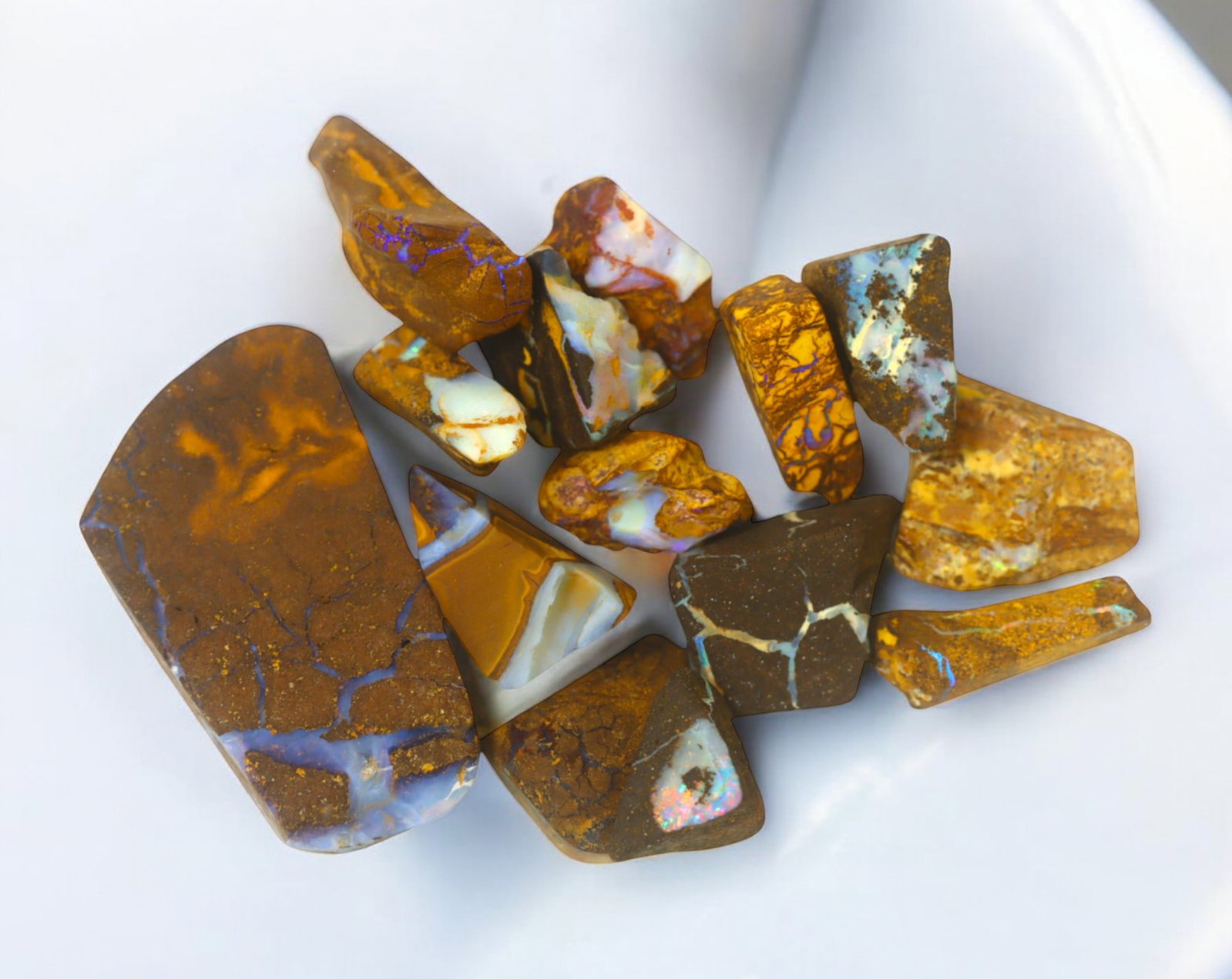 AUSTRALIAN MATRIX BOULDER OPAL - Rough Lot, 49g, 1-4cm (Images Taken Wet): A striking lot of natural Australian matrix boulder opal rough. These raw specimens display mesmerizing flashes of blue, green, and gold veins running through ironstone, characteristic of high-quality