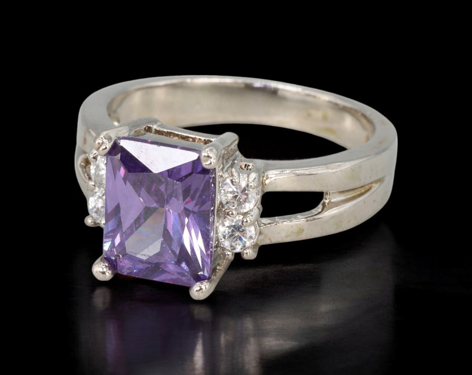 CONTEMPORARY: Ring - Silver-Tone with Emerald-Cut Violet Center and Clear Accents, US 6.2 (3.8g): A sleek and refined contemporary ring featuring an emerald-cut violet stone as the centerpiece, flanked by small clear accent stones in a classic three-stone configuration. The split-shoulder silver-t