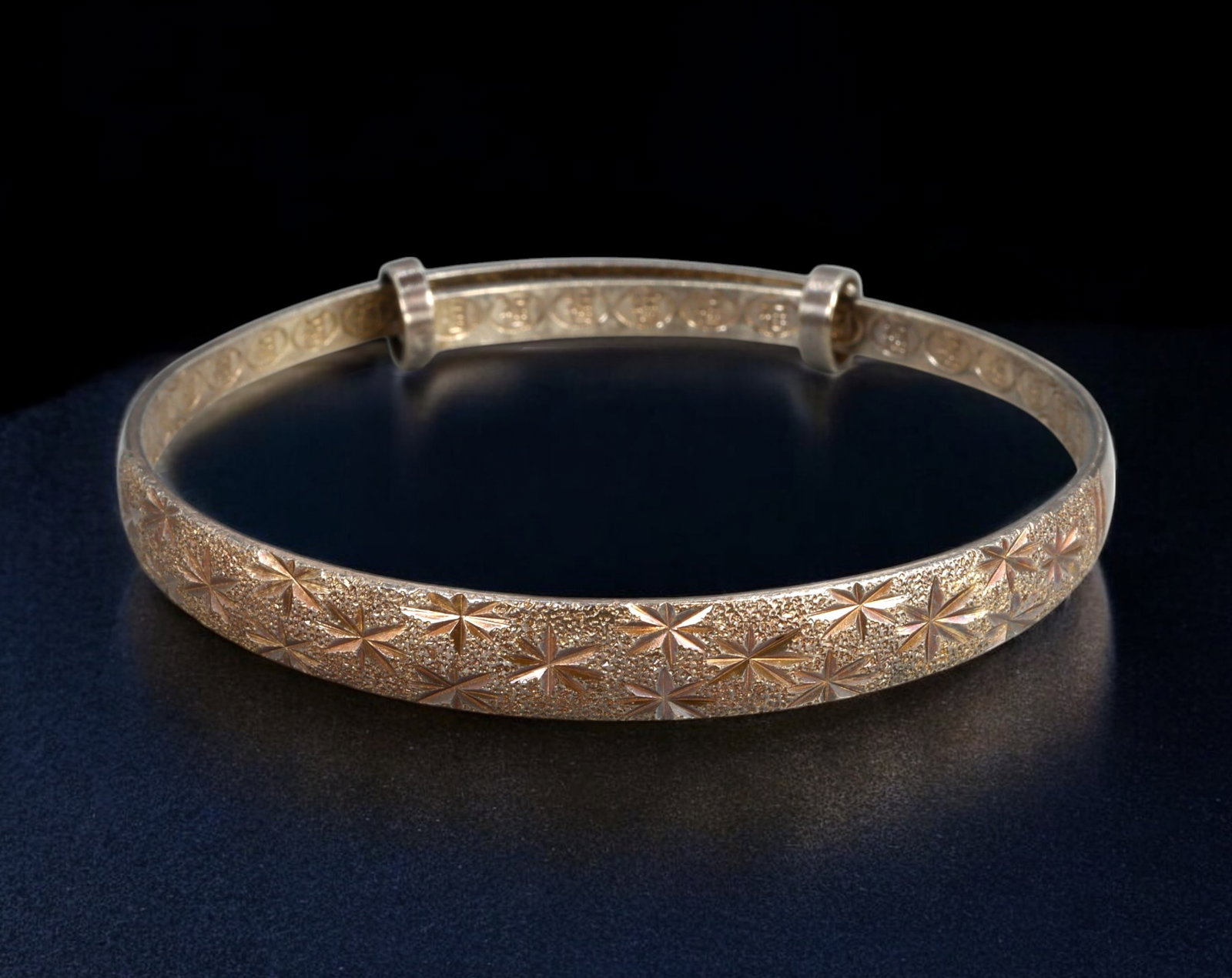 CONTEMPORARY: Bangle Sterling Silver with Starburst Engraving and Blessing Motif Lining, 6.3×6.5cm: A contemporary oval bangle in sterling silver (stamped 925), featuring a shimmering starburst engraving across the exterior surface. The interior is fully patterned with repeating circular blessing sy