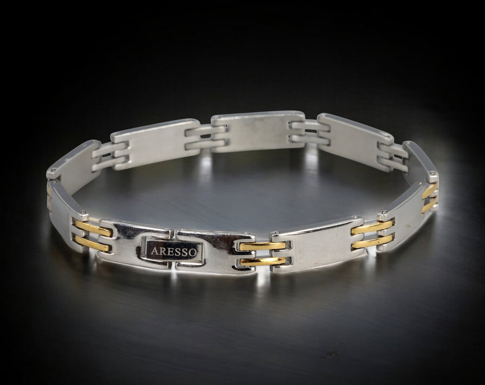 RETRO MODERN: Bracelet - ARESSO Steel Link with Gold-Tone Trim, 22.6cm (25g): A robust and masculine ARESSO stainless steel bracelet featuring a sleek articulated design with interlinked, slightly arched panels joined by gold-tone twin bar connectors. Measuring 22.6 cm in lengt