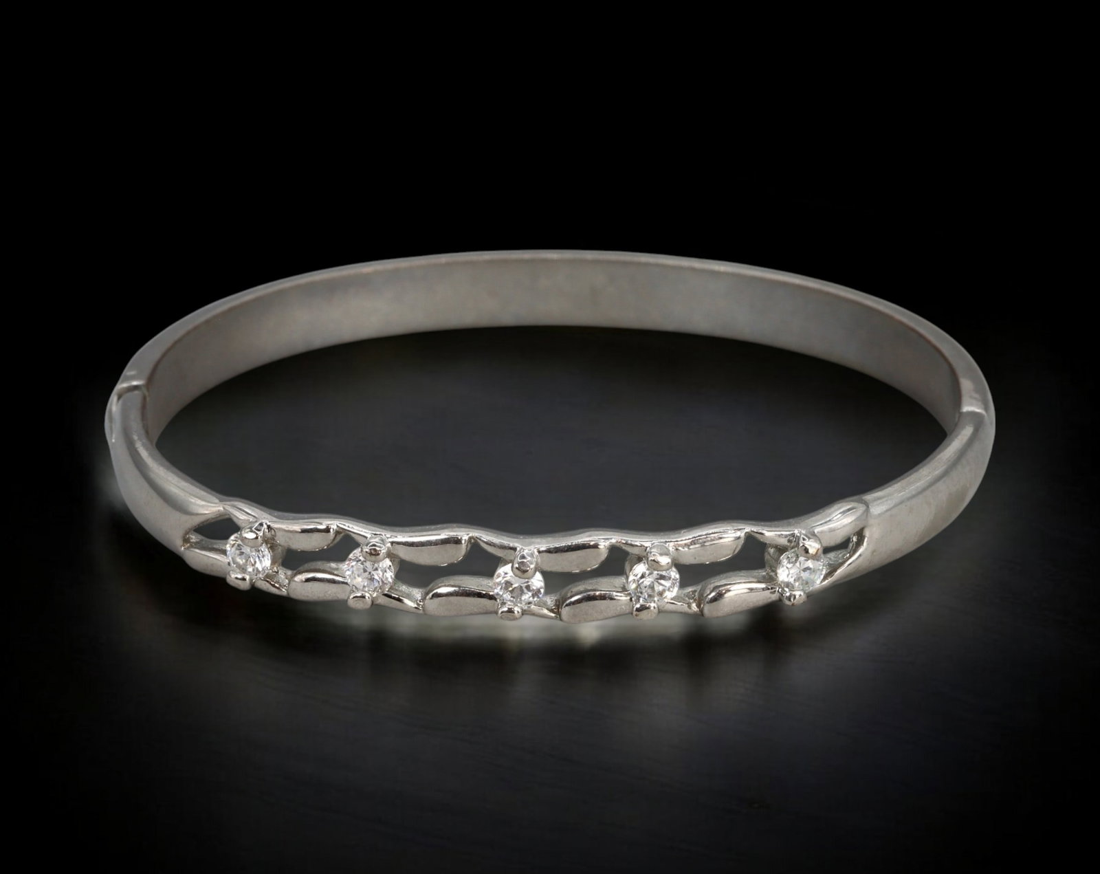 CONTEMPORARY: Bangle - Silver-Tone Oval with Openwork Vine & Crystal Accents (5.6x6.3cm, 17g): This sleek oval bangle in silver-tone metal features a front-facing openwork vine design, gently curved and punctuated with five prong-set round crystals. The symmetrical layout offers a refined spark