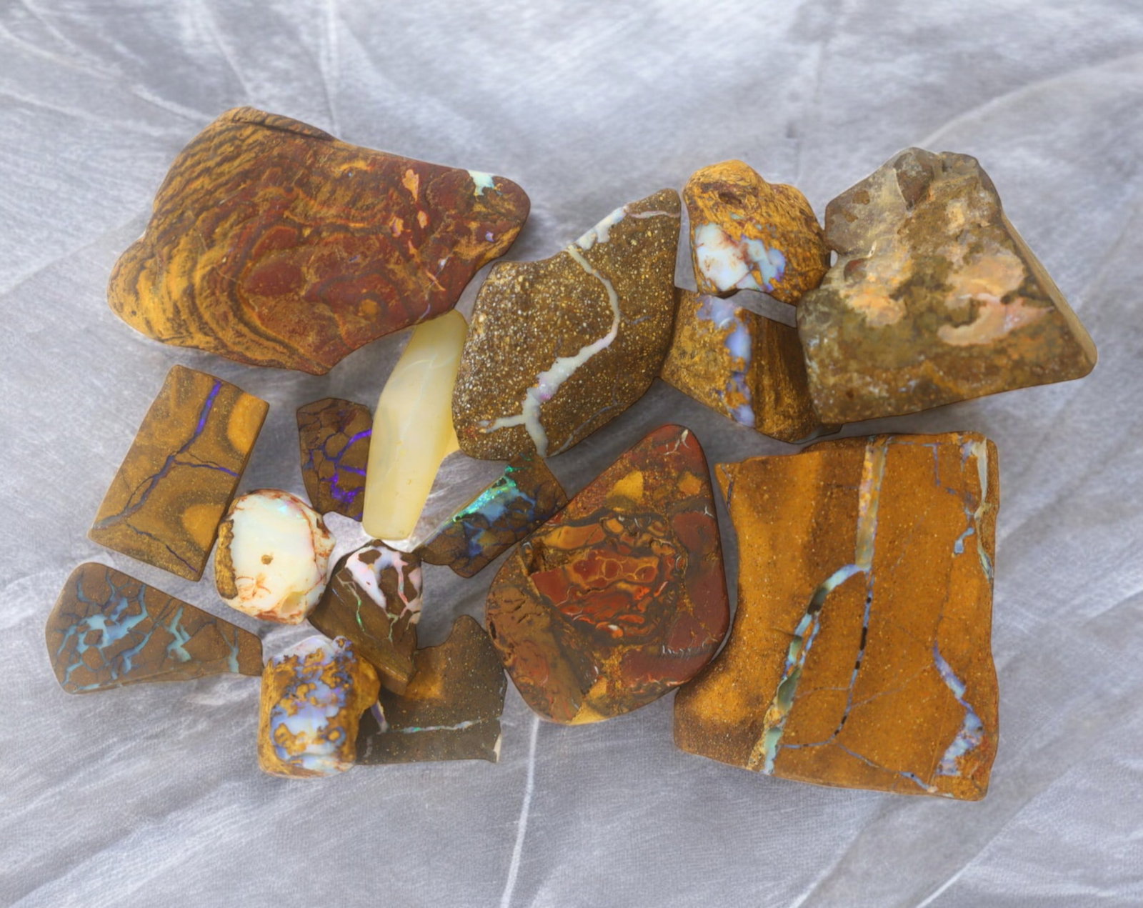 AUSTRALIA: Matrix Boulder Opal Rough Lot, 58g, 1-3.5 cm (Images Taken Wet): Stunning lot of natural Australian matrix boulder opal rough, these specimens showcase a vibrant interplay of opalized veins and swirls embedded in rich ironstone, displaying flashes of electric blues