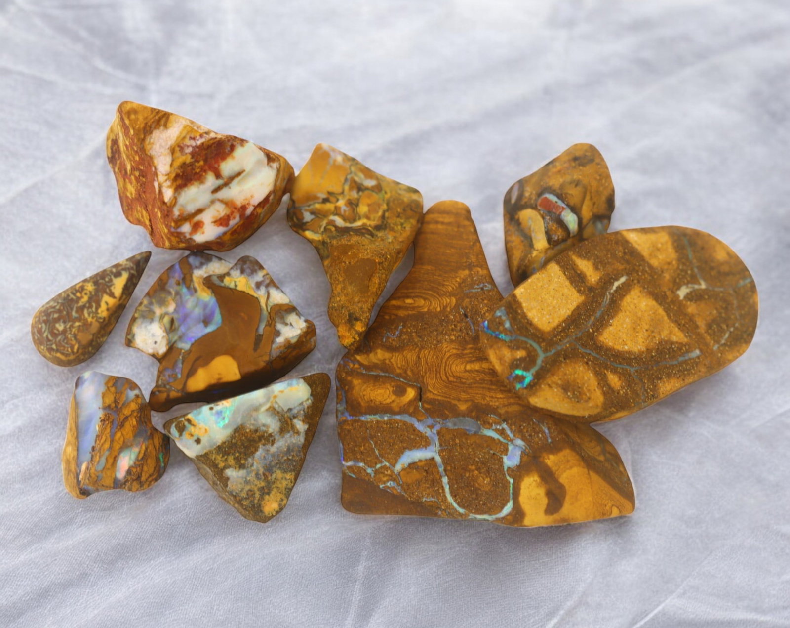 AUSTRALIA: Matrix Boulder Opal Rough Lot, 60g, 1-3.9 cm (Images Taken Wet): Stunning lot of natural Australian matrix boulder opal rough, these specimens showcase a vibrant interplay of opalized veins and swirls embedded in rich ironstone, displaying flashes of electric blues