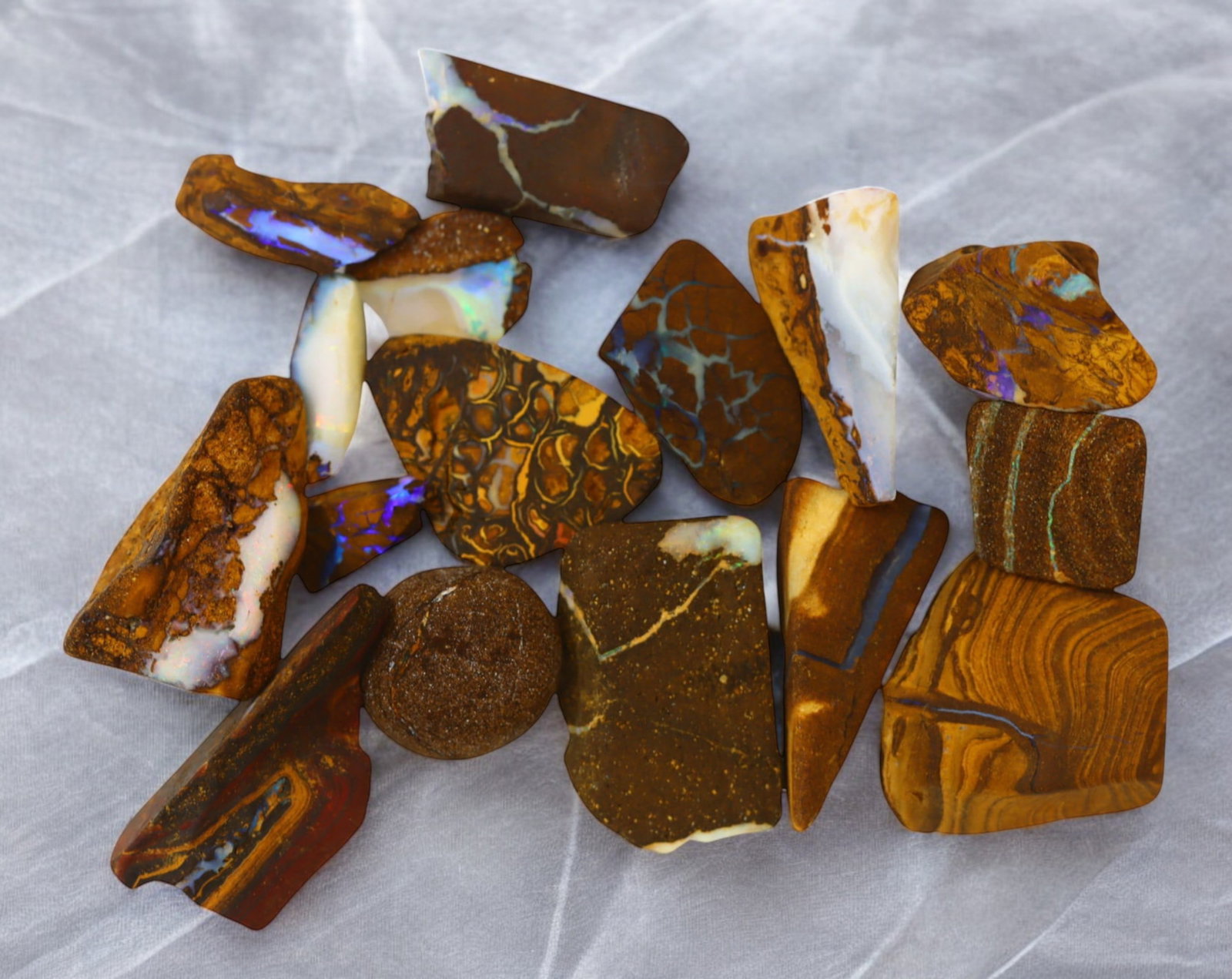 AUSTRALIA: Matrix Boulder Opal Rough Lot, 30g, 1-2 cm (Images Taken Wet): Stunning lot of natural Australian matrix boulder opal rough, these specimens showcase a vibrant interplay of opalized veins and swirls embedded in rich ironstone, displaying flashes of electric blues