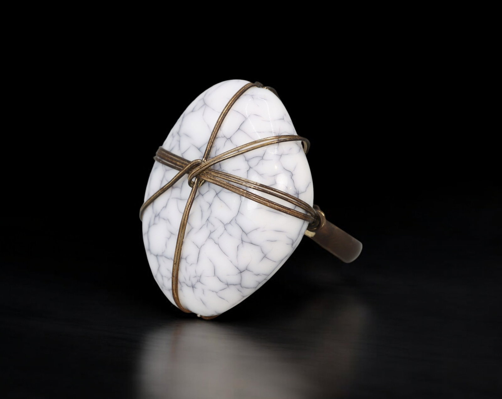 MID-CENTURY MODERNIST: Ring - White Marbled Cabochon with Brass Wire Wrap, US 5.7 (7.5g): A sculptural Mid-Century Modernist ring featuring a large, white cabochon with dramatic grey veining, secured by intersecting brass wires in a wrapped, cross-hatch formation. The open-backed setting a