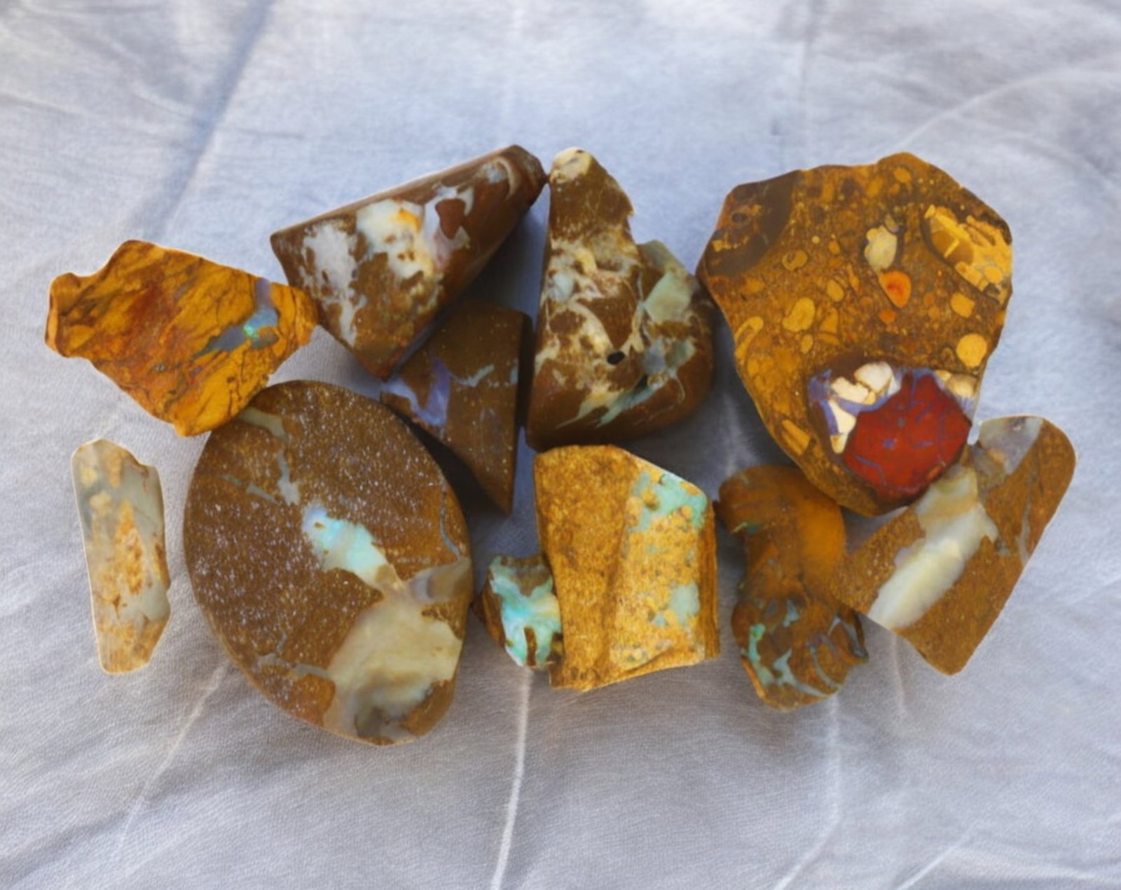 AUSTRALIA: Matrix Boulder Opal Rough Lot, 45g, 1-3.2 cm (Images Taken Wet): Stunning lot of natural Australian matrix boulder opal rough, these specimens showcase a vibrant interplay of opalized veins and swirls embedded in rich ironstone, displaying flashes of electric blues