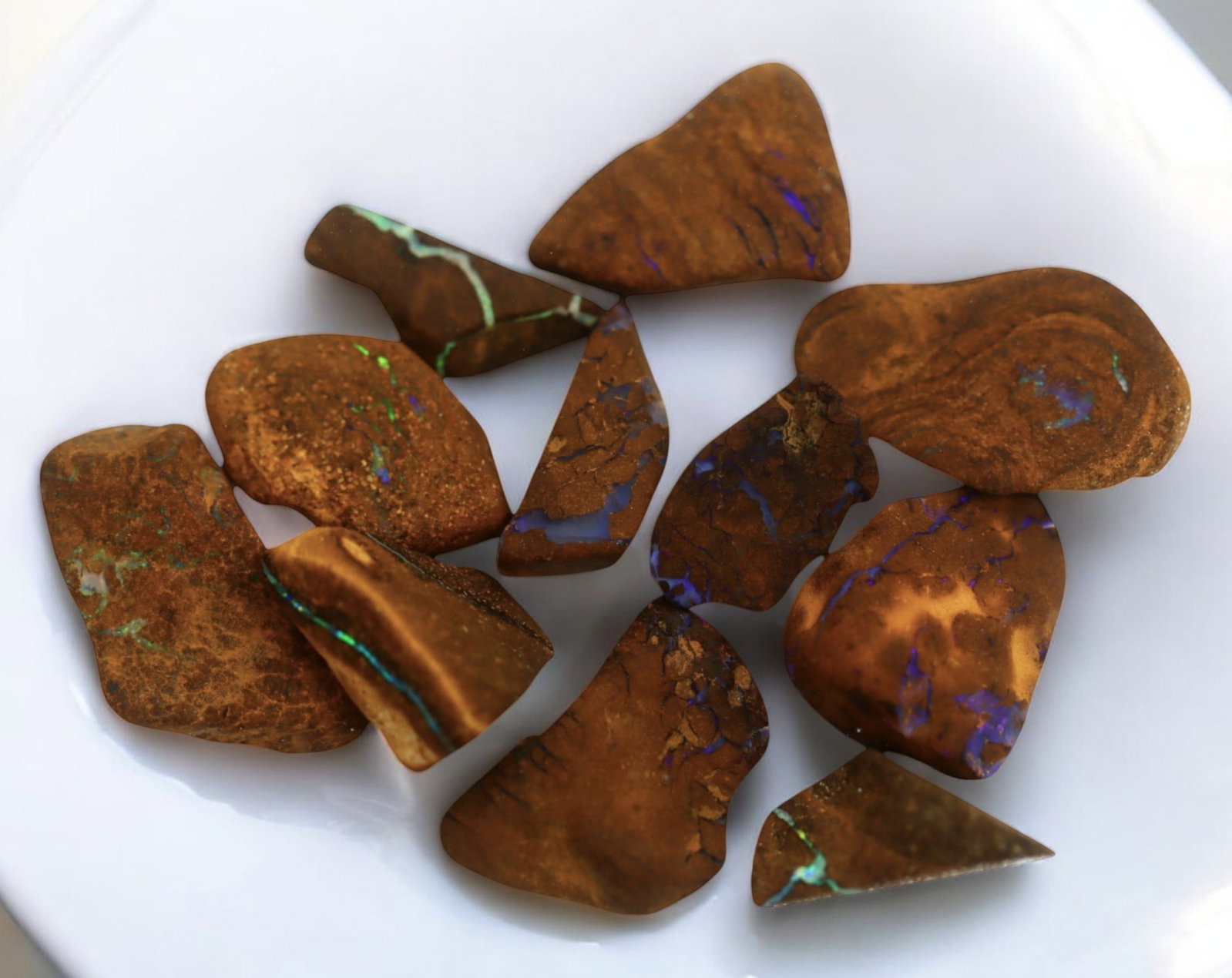 AUSTRALIAN MATRIX BOULDER OPAL - Rough Lot, 1.5-2cm, 25g: A striking lot of natural Australian matrix boulder opal rough. These raw specimens display mesmerizing flashes of blue, green, and gold veins running through ironstone, characteristic of high-quality