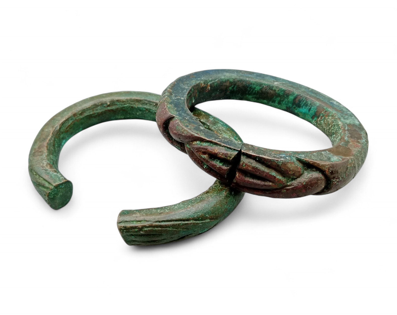 AFRICAN TRIBAL: Currency Bracelet Lot - Verdigris Patina, Sculptural Forms (990g, 2pcs): An evocative pair of African tribal currency bracelets, these richly patinated pieces reflect both artistry and functional heritage. Cast in heavy form with distinctive sculptural motifs, each bracele