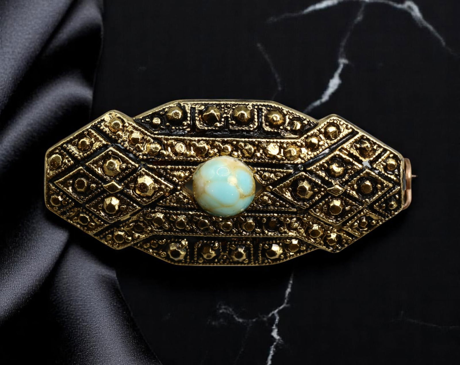VINTAGE MID-CENTURY: Brooch - Textured Geometric Panel with Opal-Effect Cabochon, 4x2cm: This mid-century vintage brooch features an elongated geometric panel design rendered in richly textured goldtone metal, adorned with raised diamond motifs and detailed dotwork. At its center lies a l