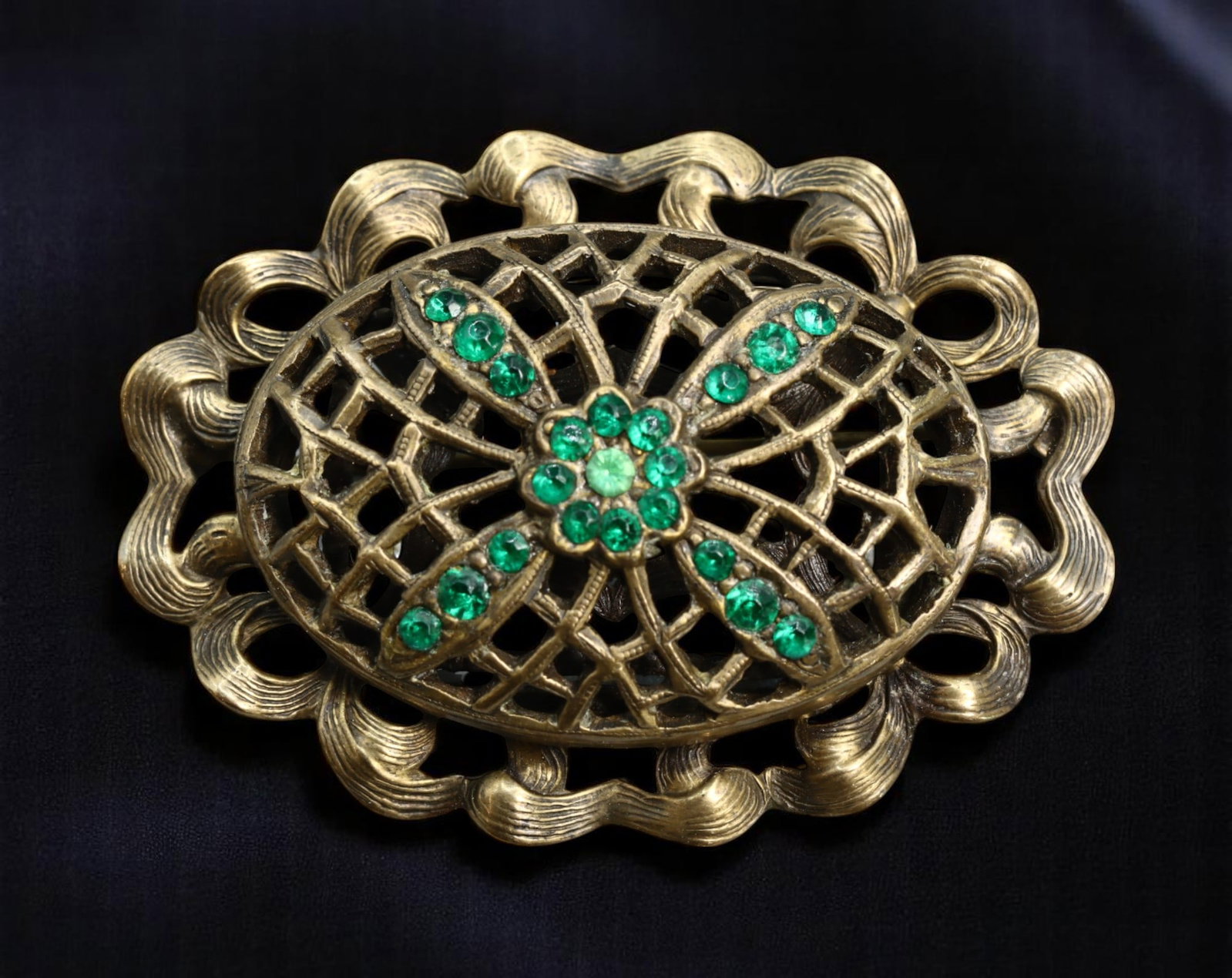 VINTAGE FLORAL REVIVAL: Brooch - Emerald-Tone Stones & Filigree Ribbon Frame, Antique, 4.6x3.5cm: A richly styled vintage brooch in the Floral Revival tradition, this openwork piece features a ribbon-like frame with scalloped edges, enclosing a central floral form set with brilliant-cut emerald-to