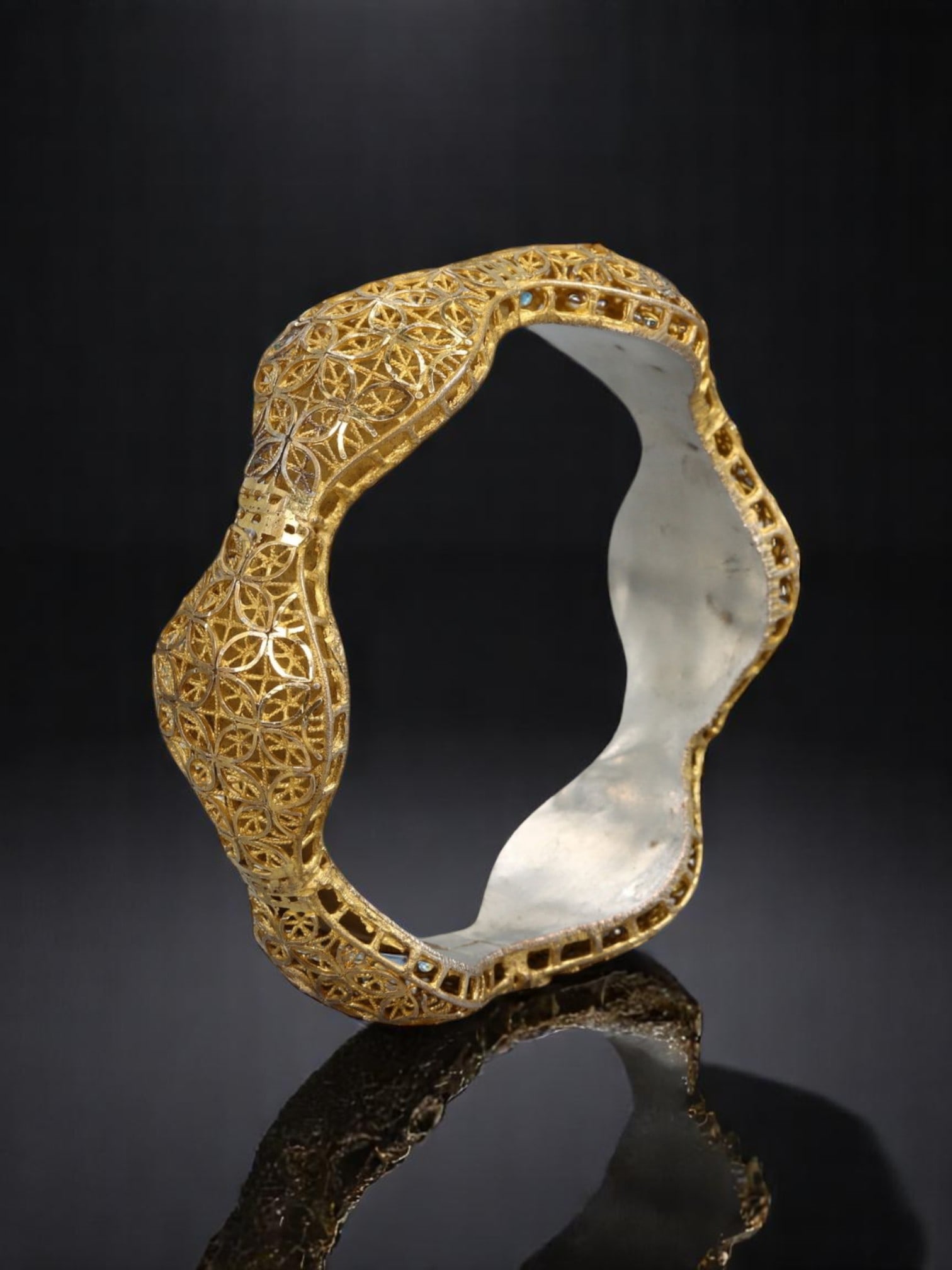MID-CENTURY FOLK REVIVAL: Sculptural Filigree Bracelet - Waved Silhouette, Goldtone Over Openwork: A striking example of mid-century Continental filigree revival, 8cm in diameter, this bracelet features an undulating sculptural form adorned in applied goldtone openwork. The repeating petal-lattice