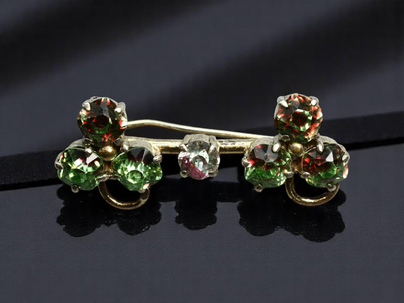 MID-CENTURY STYLE: Small Bar Brooch - Clover Motif with Green-Red Color-Shift Stones, 4x1.8cm: A compact yet vibrant piece of mid-century flair, this bar brooch features two clover-like clusters set with green-to-red shift stones that flash with dynamic color. A single clear stone accent rests 