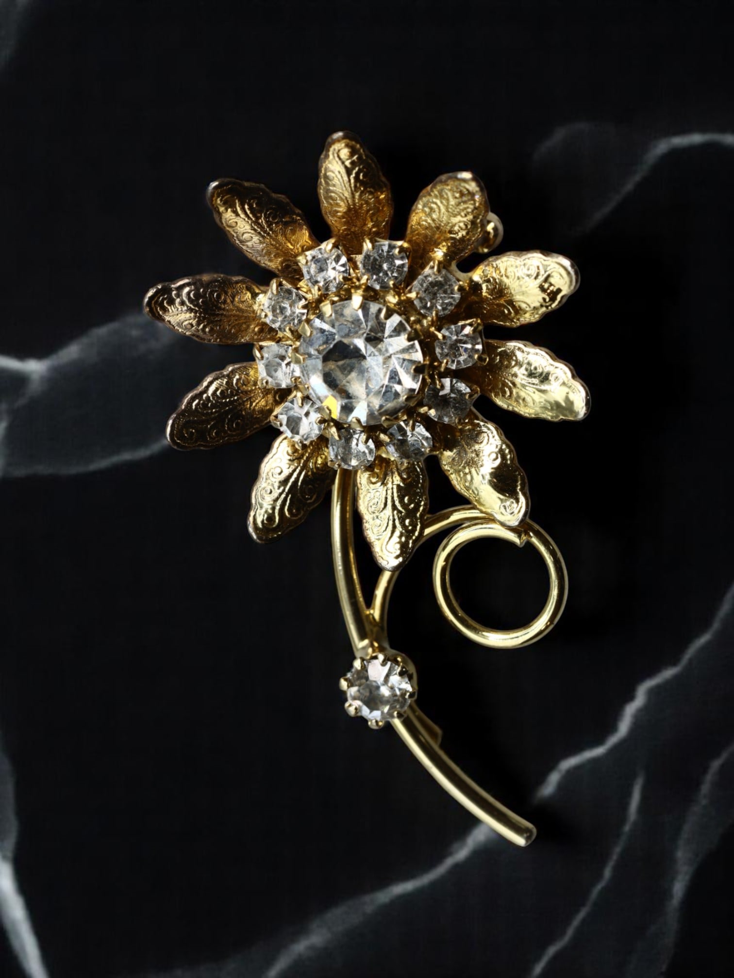 VINTAGE ROMANTIC STYLE: Floral Brooch - Etched Petals & Brilliant-Cut Clear Stones, Goldtone (5x3cm): A radiant vintage brooch celebrating the timeless elegance of floral form, this goldtone piece features delicately textured petals radiating around a brilliant-cut clear centerpiece. Eight smaller sto