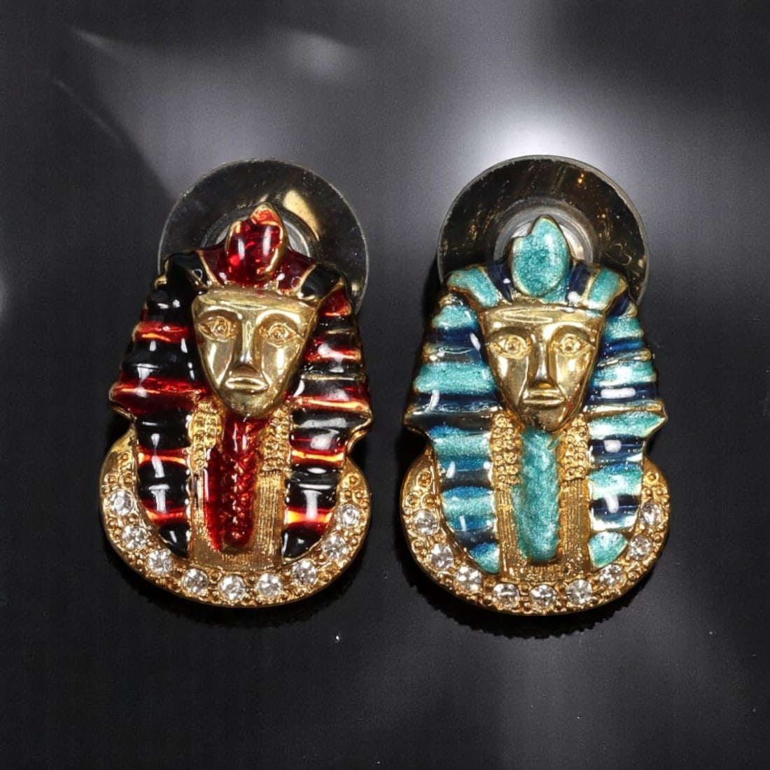 VINTAGE STATEMENT STYLE: Pharaoh Motif Earrings - Enamel & Clear Stones 2.3x1.5cmVINTAGE STATEMENT: From a curated estate collection, this vibrant pair of vintage earrings reinterprets ancient Egyptian regality through 1980s maximalist flair. Crafted in goldtone with vivid enamel detailing-one in tu