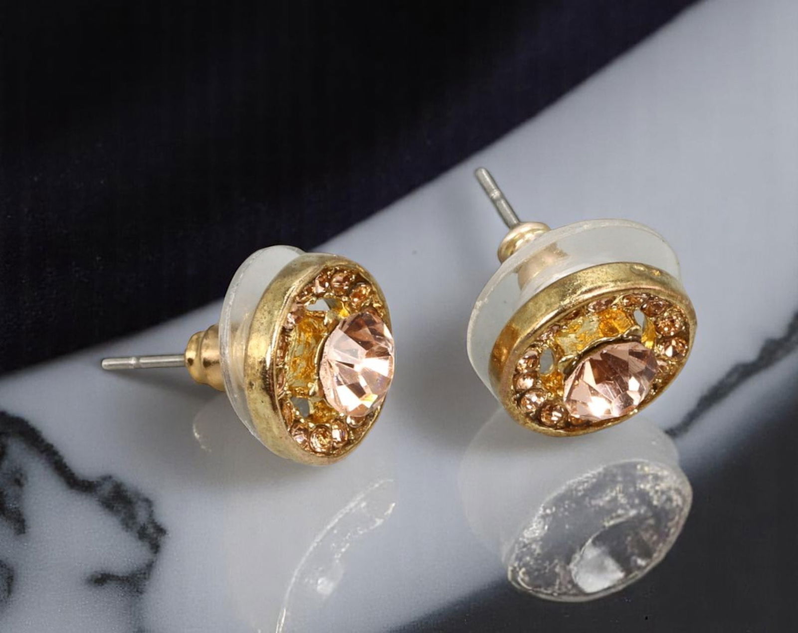 VINTAGE: Stud Earrings - Pink & Amber Brilliant-Cut Stones in Goldtone Bezel, 1cm: Estate Jewelry with delicate radiance, these vintage stud earrings feature a central pink brilliant-cut stone encircled by amber-hued accents, all set in a polished goldtone bezel. Measuring 1cm, thei