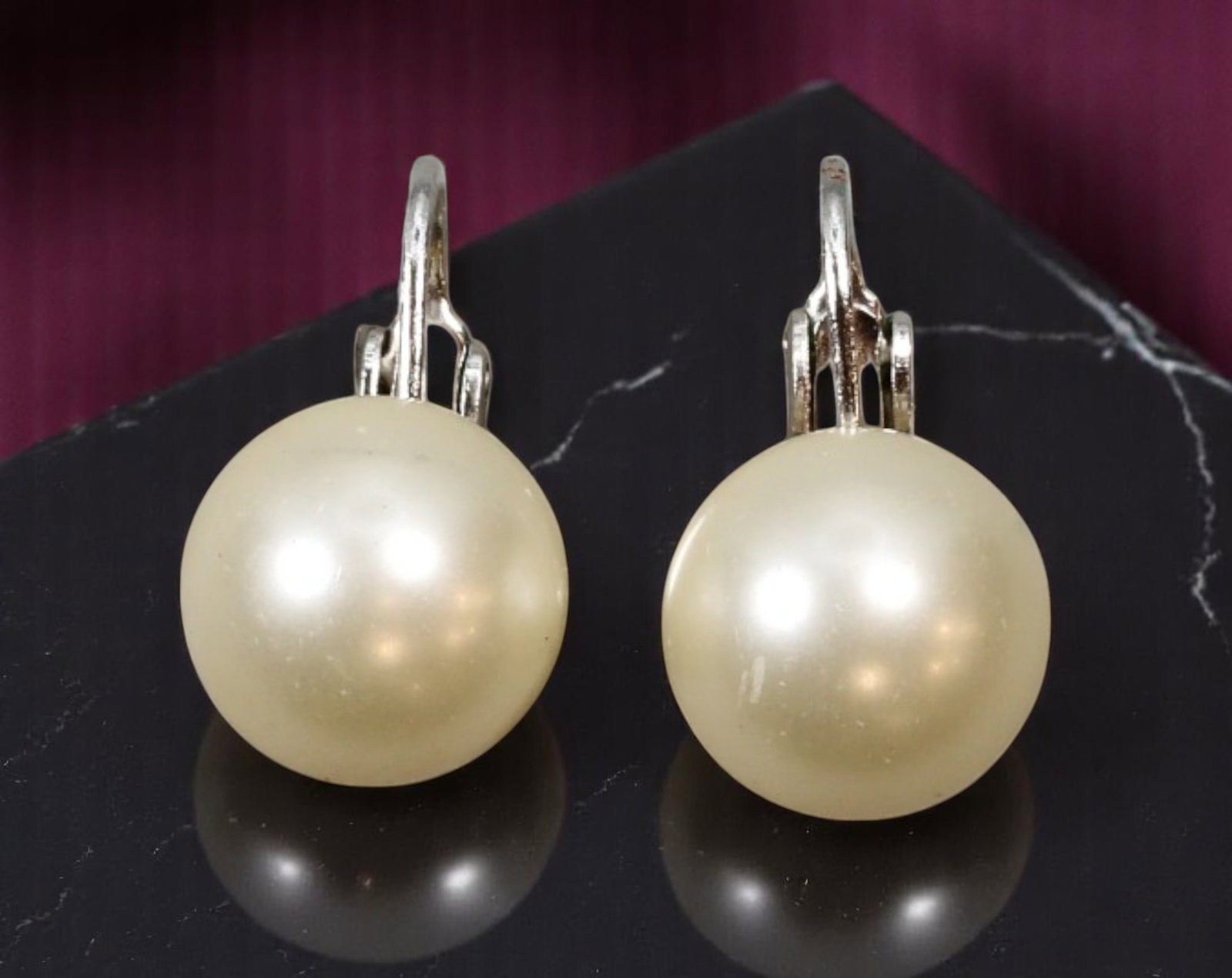 TRIFARI: MID-CENTURY Clip-On Earrings - Pearl-Like Domes in Silvertone Basket Setting, 1.8x1cm: Estate Jewelry by iconic maker Trifari, these signed vintage clip-on earrings feature luminous pearl-like domes set in refined silvertone basket-style prongs. Measuring 1.8x1cm, the earrings embody th