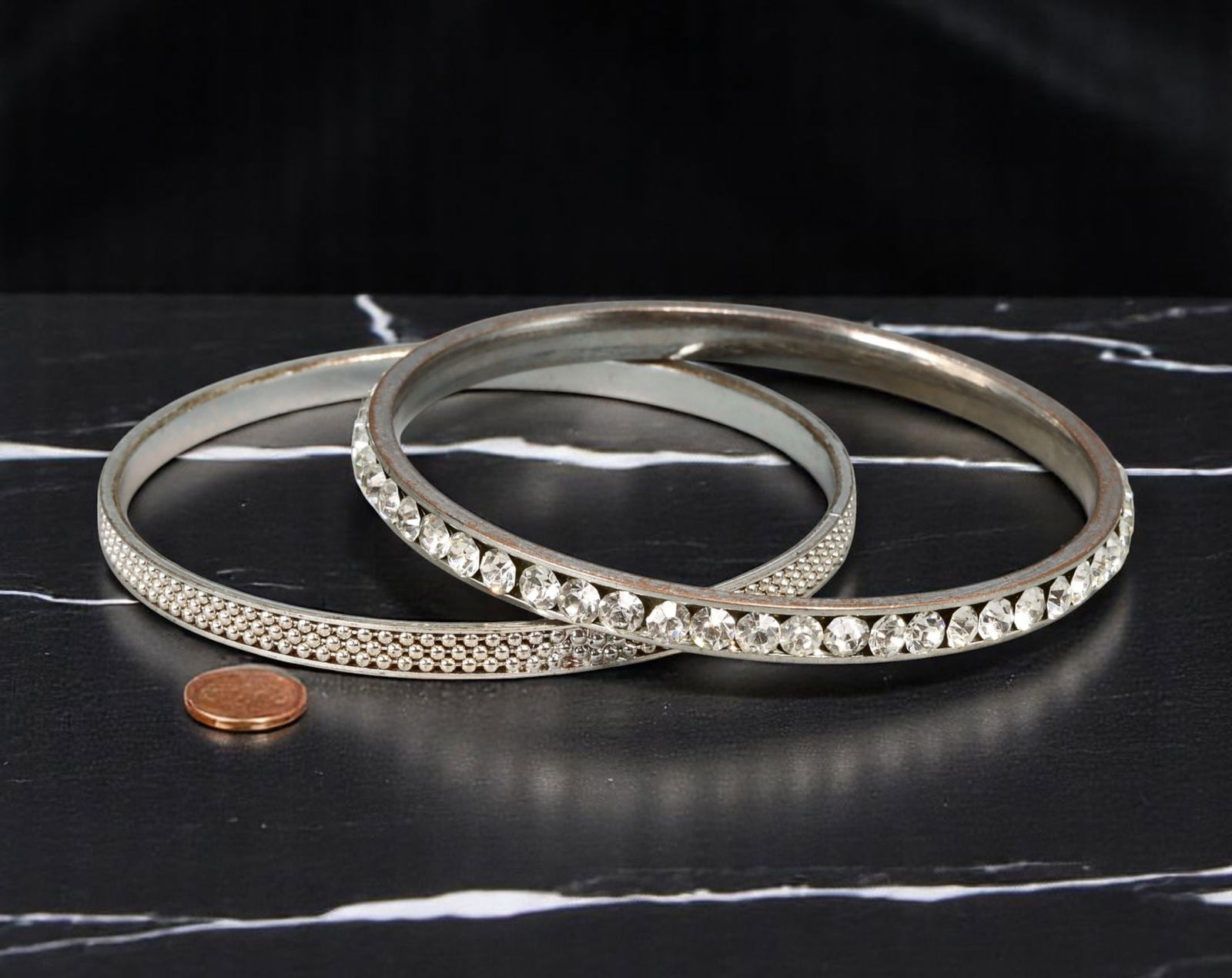 Bangle Duo - Pave & Beaded Texture, Clear Stone Accents, Silvertone (7cm): This sparkling bangle duo features two coordinating silvertone bracelets: one lined with brilliant-cut clear stones in a channel setting, and the other detailed with a dense beaded texture for visual