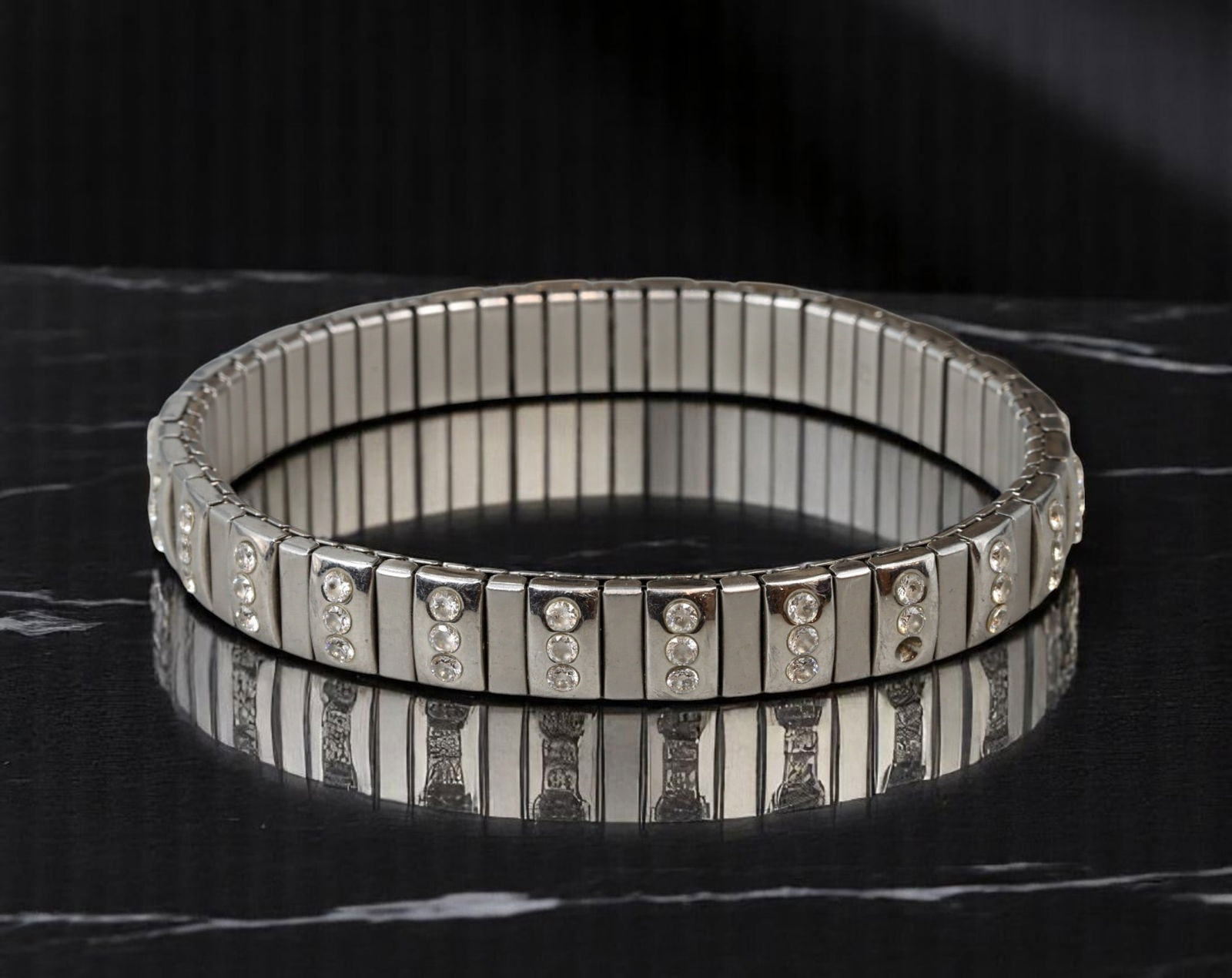 BOLD STATEMENT ERA: Stretch Bracelet - Clear Stone Accents, Silvertone Finish (6 cm): Embodying bold yet versatile design, this vintage stretch bracelet offers sculptural appeal with a rhythmic arrangement of clear stone accents across polished silvertone segments. The flexible constru