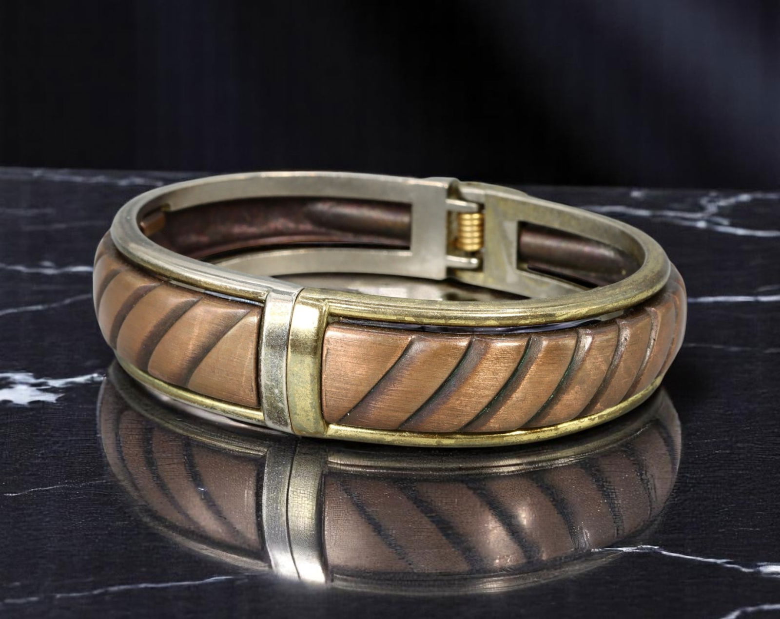 Hinge Bracelet - Brushed Copper-Tone with Diagonal Carving, 7cm: This sculptural hinge bracelet showcases a bold brushed copper-tone finish with rhythmic diagonal striping, framed in a soft antiqued goldtone border. The design merges industrial and artisan aestheti