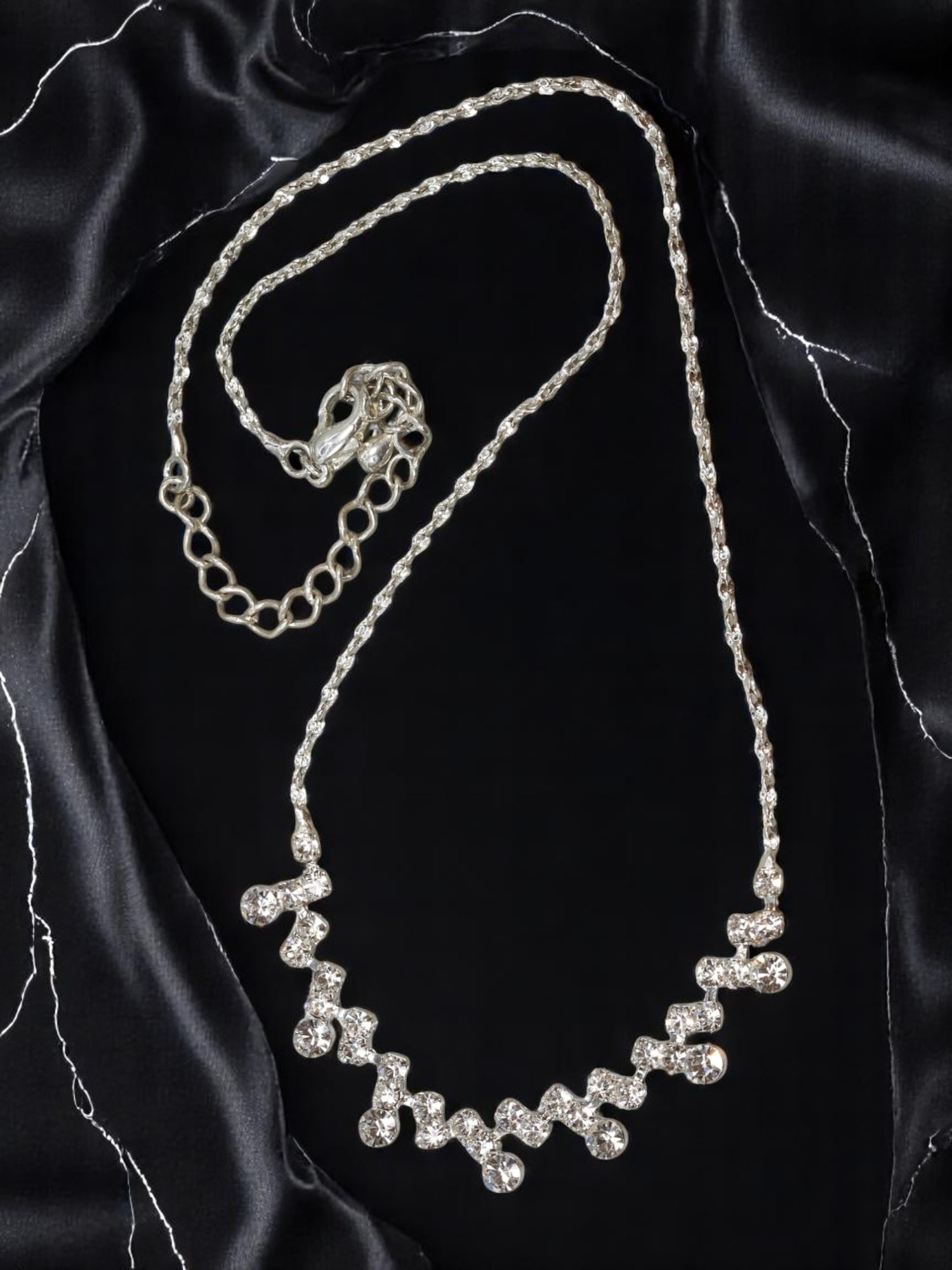 CONTEMPORARY: Crystal Necklace - Graduated Clear Stones, Silvertone Rope Chain (40cm): A brilliant contemporary necklace showcasing graduated clear stones arranged in a lively zigzag pattern, suspended from a textured silvertone rope chain. Measuring approximately 40 cm in length with a