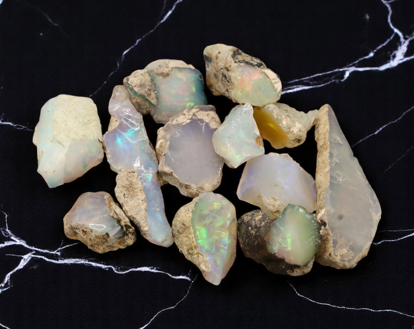 GEM LOT: Ethiopian Welo Opal Rough - Iridescent Play-of-Color in Matrix, Mixed Forms (12g): An estate-sourced parcel of natural Ethiopian Welo Opal rough, totaling 11 grams, this lot features raw, matrix-hosted specimens with vibrant play-of-color across milky, translucent, and honey-toned b