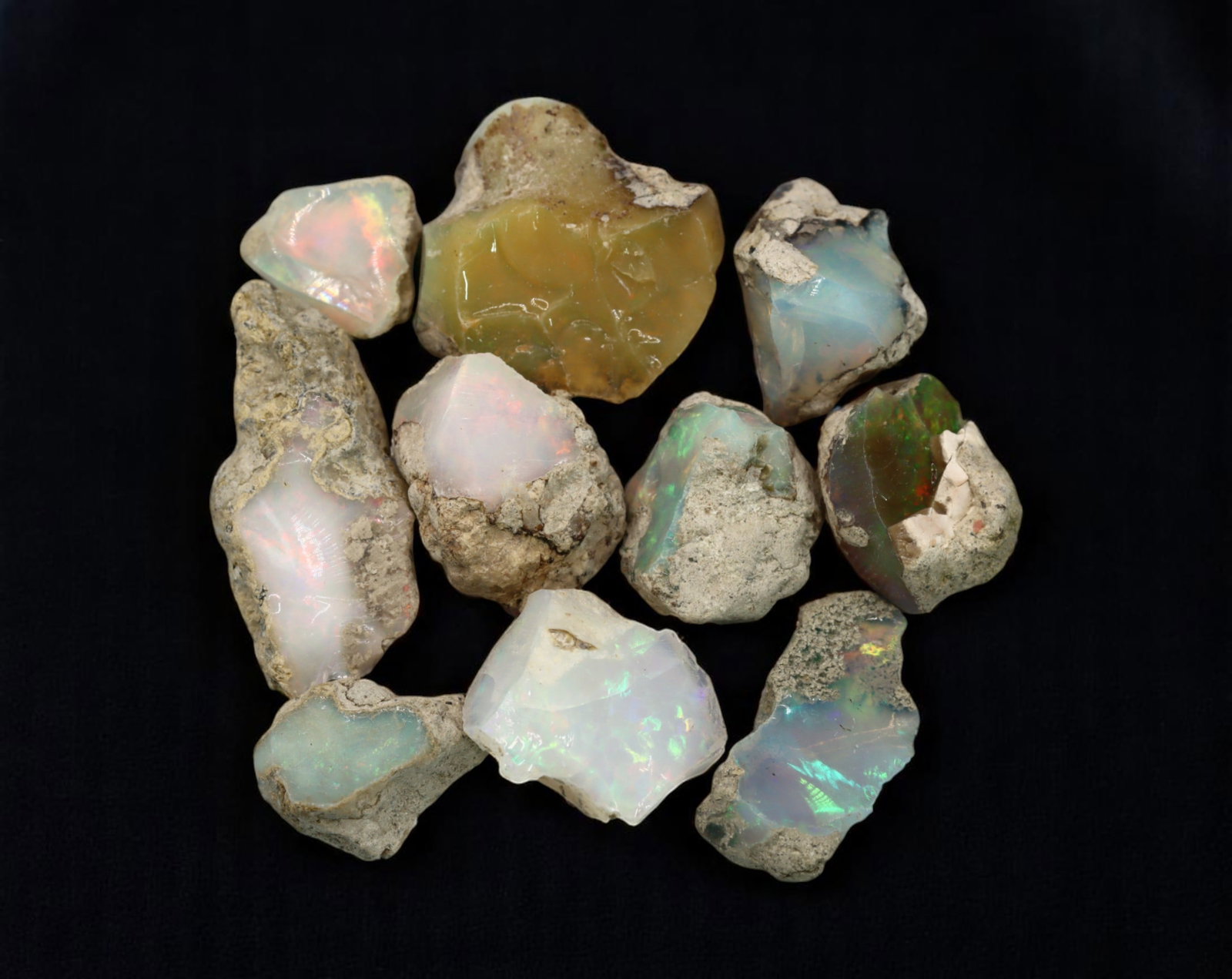 GEM LOT: Ethiopian Welo Opal Rough - Iridescent Play-of-Color in Matrix, Mixed Forms (13g): An estate-sourced parcel of natural Ethiopian Welo Opal rough, totaling 11 grams, this lot features raw, matrix-hosted specimens with vibrant play-of-color across milky, translucent, and honey-toned b
