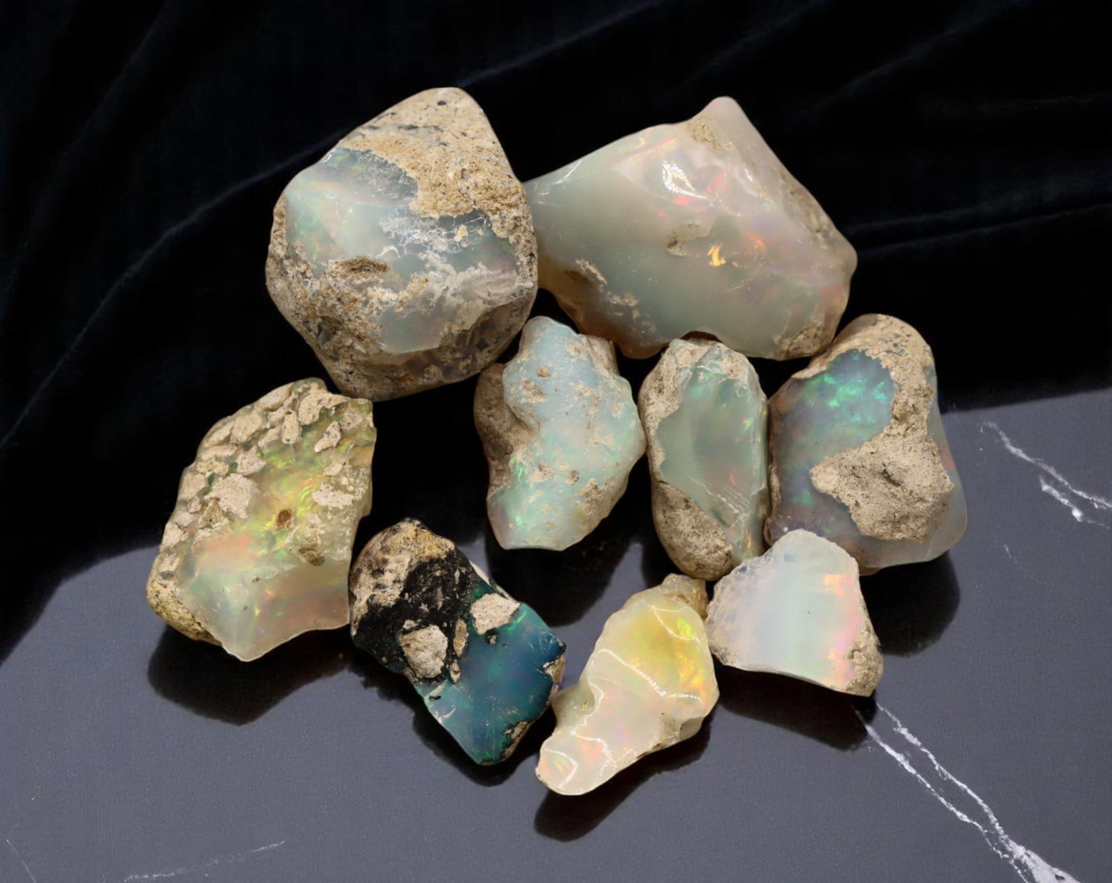 GEM LOT: Ethiopian Welo Opal Rough - Iridescent Play-of-Color in Matrix, Mixed Forms (13g): An estate-sourced parcel of natural Ethiopian Welo Opal rough, totaling 11 grams, this lot features raw, matrix-hosted specimens with vibrant play-of-color across milky, translucent, and honey-toned b