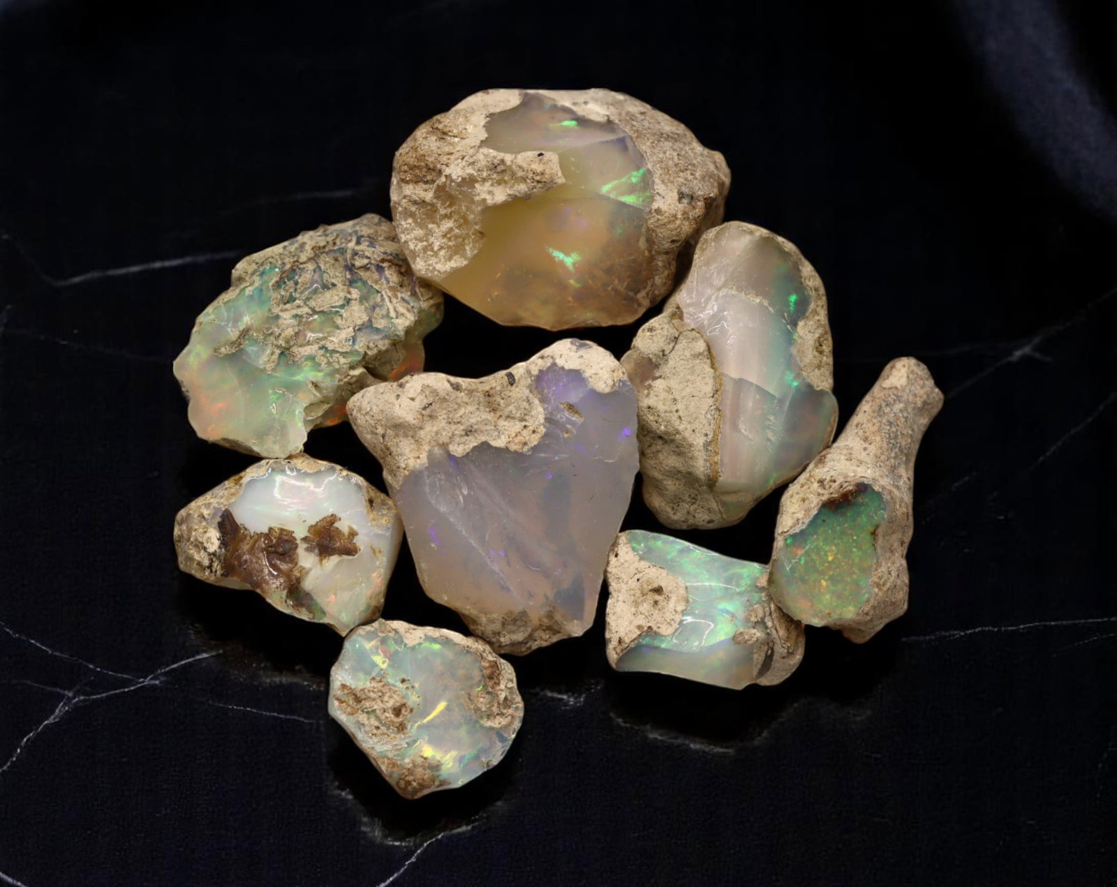 GEM LOT: Ethiopian Welo Opal Rough - Iridescent Play-of-Color in Matrix, Mixed Forms (14g): An estate-sourced parcel of natural Ethiopian Welo Opal rough, totaling 11 grams, this lot features raw, matrix-hosted specimens with vibrant play-of-color across milky, translucent, and honey-toned b