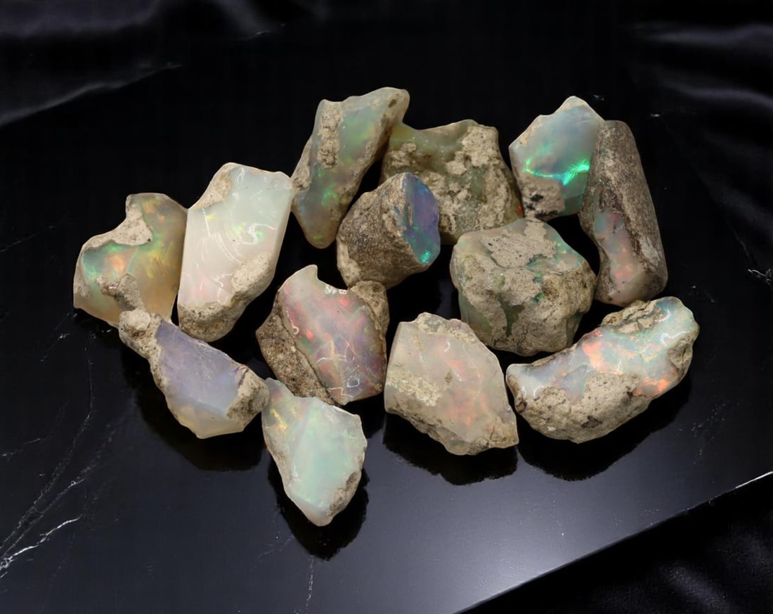 GEM LOT: Ethiopian Welo Opal Rough - Iridescent Play-of-Color in Matrix, Mixed Forms (12g): An estate-sourced parcel of natural Ethiopian Welo Opal rough, totaling 11 grams, this lot features raw, matrix-hosted specimens with vibrant play-of-color across milky, translucent, and honey-toned b