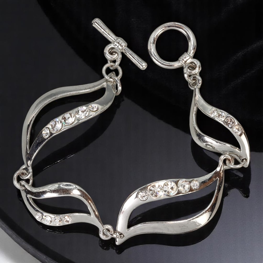 Bracelet - Sculptural Leaf Motif Links with Clear Stones, Silvertone, 18cm: A graceful example of contemporary jewelry design, this sculptural link bracelet features flowing, openwork leaf motifs set with brilliant-cut clear stones. The silvertone finish enhances the sleek li