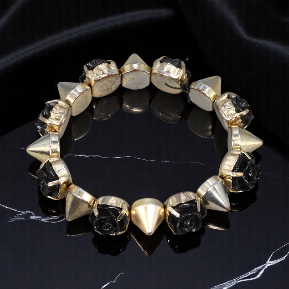 Estate Stretch Bracelet - Goldtone Pyramid Spikes and Black Rose Accents, 17cm: An eye-catching estate jewelry piece from the late 20th century, this stretch bracelet features alternating goldtone pyramid spike beads and sculpted black rose elements. The combination of hard-edged