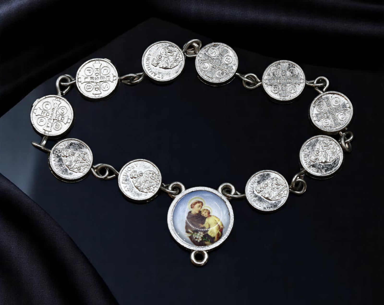 Estate Bracelet - Religious Medal & Coin Charm Style, 15cm: An evocative example of Estate jewelry, this vintage mid-century bracelet features a sculptural arrangement of religious medal-style and coin-like charms, linked together in a continuous band. At its