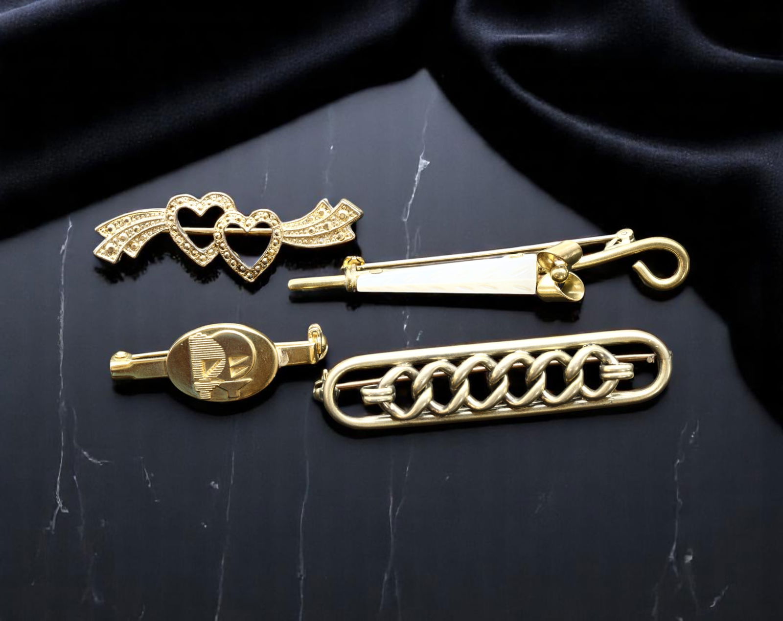 Brooch Lot - Goldtone, Heart, Nautical, Floral & Chain Motifs (6.5-4.5cm, 4 Pieces): An intriguing collection of four vintage brooches showcasing the versatile creativity of late 20th-century jewelry design. This curated lot includes: a goldtone double open-heart brooch with ribbon-li