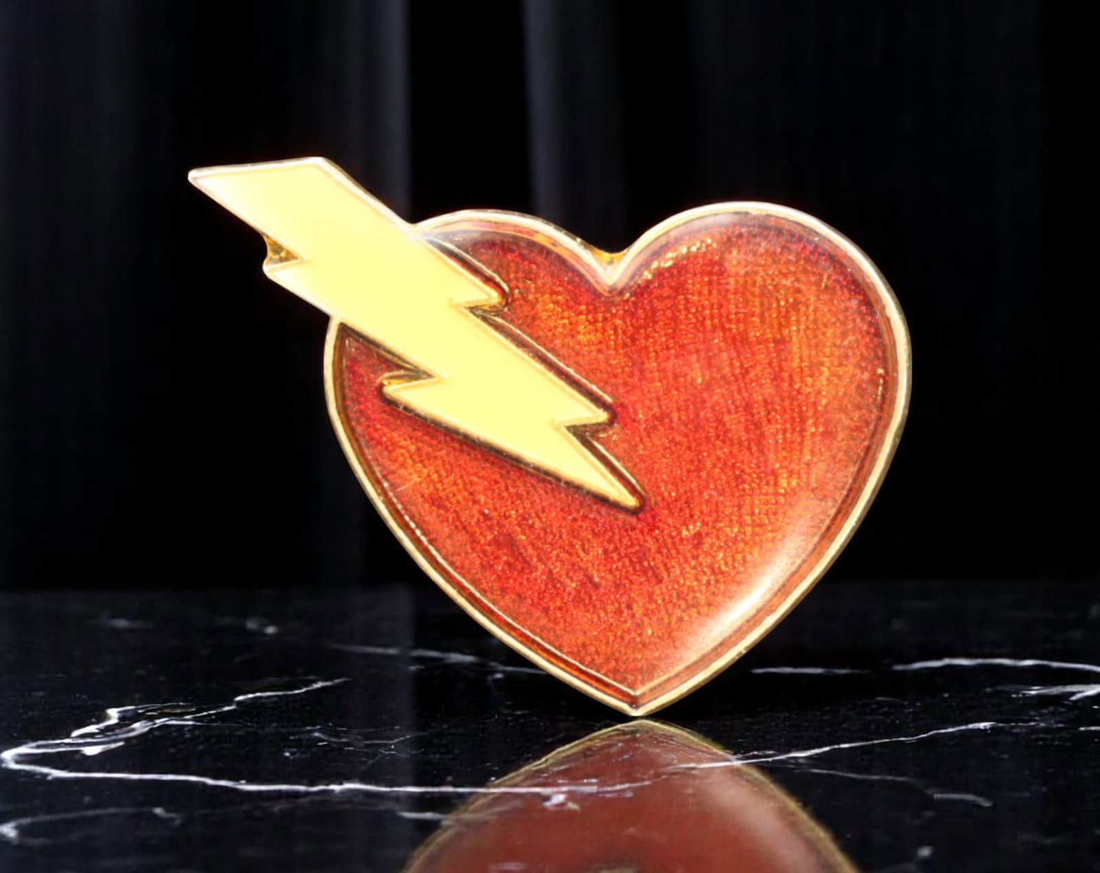 ARTISAN: Pin Brooch - Red Heart & Yellow Lightning Bolt Motif, Gloss Finish (2.8x2cm): Playful yet bold, this contemporary artisan brooch captures pop art flair with its stylized red heart punctuated by a vivid yellow lightning bolt. The high-gloss surface amplifies the strong color con