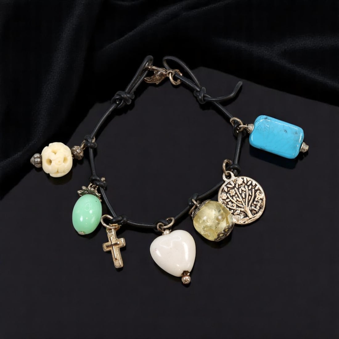 Charm Bracelet - Black Cord with Mixed Beads, Charms & Tokens, 18cm: A bold and eclectic vintage-inspired charm bracelet featuring a black cord base with knotted detailing and an assortment of sculptural beads, tokens, and charms. Elements include turquoise-like and ja