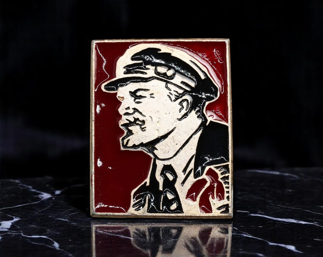 USSR: Lenin in Revolutionary Cap - Soviet Proletarian Leadership Commemorative Badge, 1970s, 27x21mm: This powerful 27x21mm badge captures the unmistakable image of Vladimir Lenin wearing his iconic proletarian cap, symbolizing the unyielding determination and vision of the Soviet revolutionary moveme