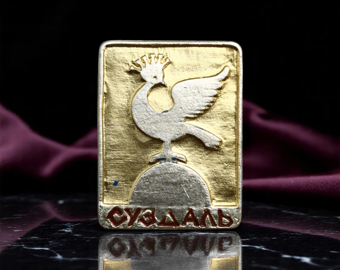 USSR: Suzdal - Cultural Heritage Rooster Emblem Pin, ca. 1970s, 22x18mm: Embodying the proud heritage of one of Russia's most historic Golden Ring cities, this vintage Soviet pin from the 1970s celebrates the town of Suzdal with its iconic crowned rooster motif. The styliz