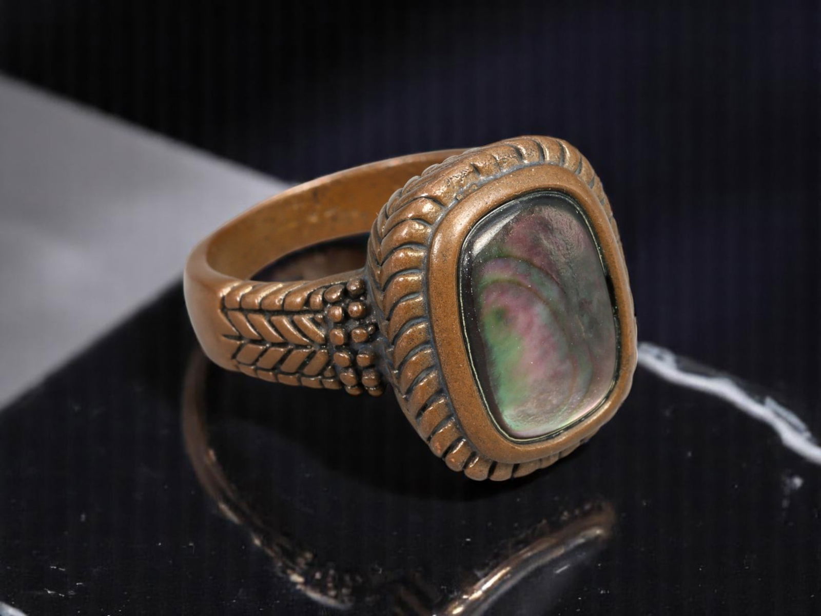 ETHNIC REVIVAL: Bronze-Tone Ring - Sculptural Bezel with Iridescent Shell-Like Cabochon, US 8: This richly textured ethnic revival style ring features a warm bronze-tone setting with intricate sculptural details, including rope-like framing and beadwork accents along the shoulders. The centerpi