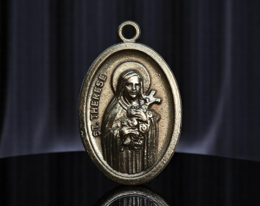 ITALY: St. Therese of Lisieux - The Little Flower Devotional Medal, ca. 1960s, 25mm: This Italian devotional medal honors St. Therese of Lisieux, affectionately known as "The Little Flower," one of the most beloved modern saints. Clad in Carmelite robes, she cradles a crucifix intertw