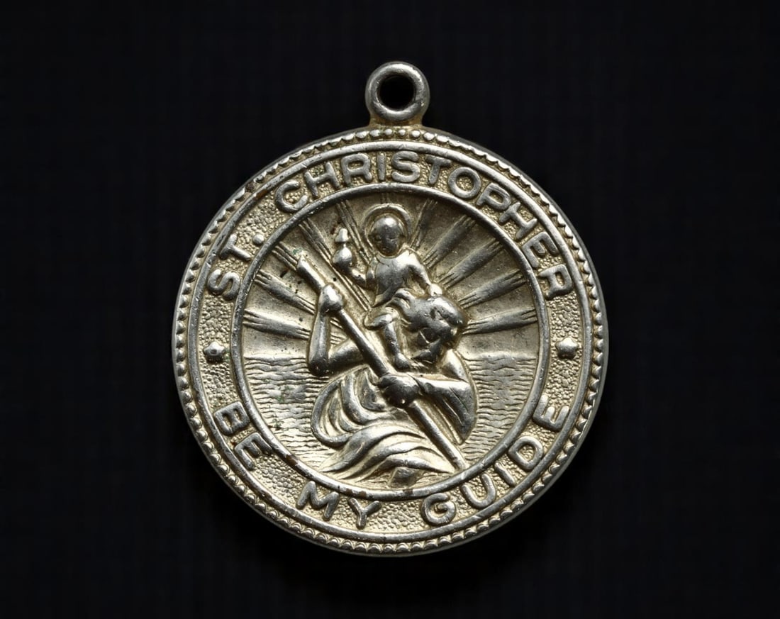 USA: Travel Protection - St. Christopher 'Be My Guide' Medal, c.1950s, 34mm: A quintessential mid-century devotional item, this 34mm silver-toned medal honors St. Christopher, the legendary patron saint of travelers. The obverse depicts the iconic image of the saint bearing th