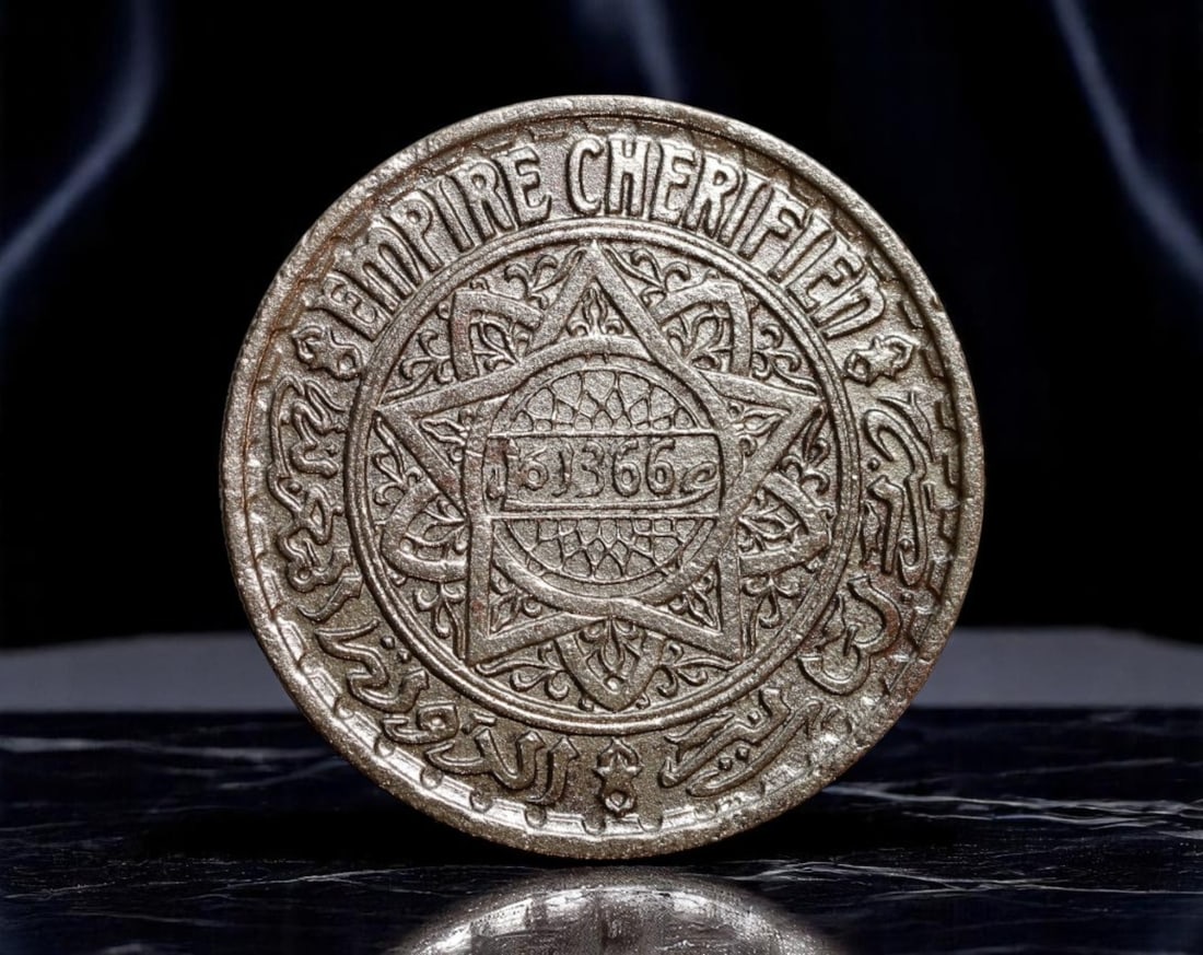 MOROCCO: Imperial Ornamentation - Sherifian Empire 10 Francs Coin, 1366 AH (1947 AD), 25mm: A richly detailed emblem of Morocco's late colonial-era sovereignty, this 10 Francs coin from the Sherifian Empire was issued during the reign of Sultan Mohammed V. The focal motif is the ornate Seal 