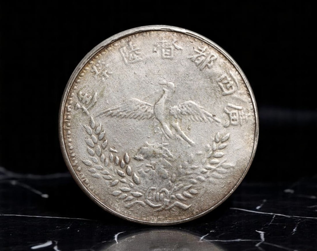 CHINA/WARLORD ERA: Guangxi Province - Flying Phoenix Provincial Token, ca. 1920s, 23mm: Struck during the turbulent Chinese Warlord Era, this provincial token from Guangxi evokes a unique blend of local governance and symbolic renewal. One side bears a stylized bust of a uniformed offici