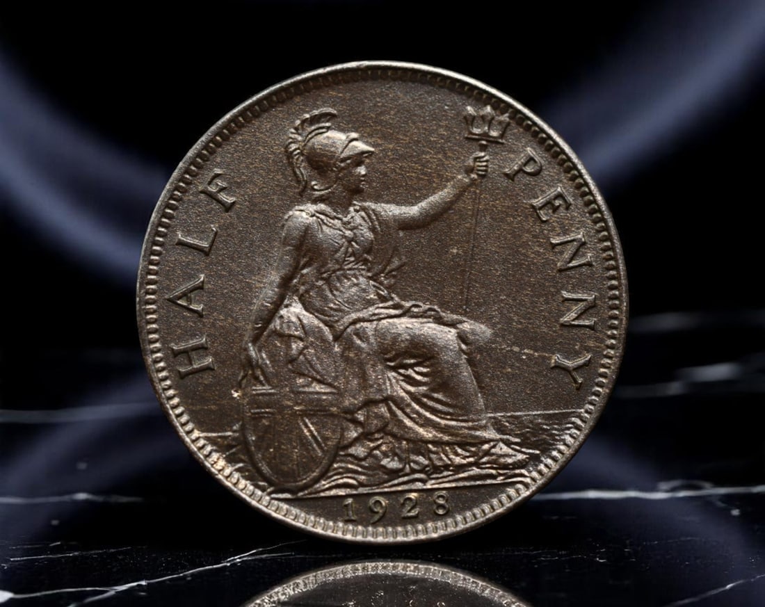 UNITED KINGDOM: King George V - Britannia Maritime Sovereignty Half Penny Coin, 1928, 25mm: Issued during the twilight years of the British Empire's global dominion, this 1928 Half Penny showcases King George V's commanding profile, a visage of stability amid changing tides. Britannia, drape