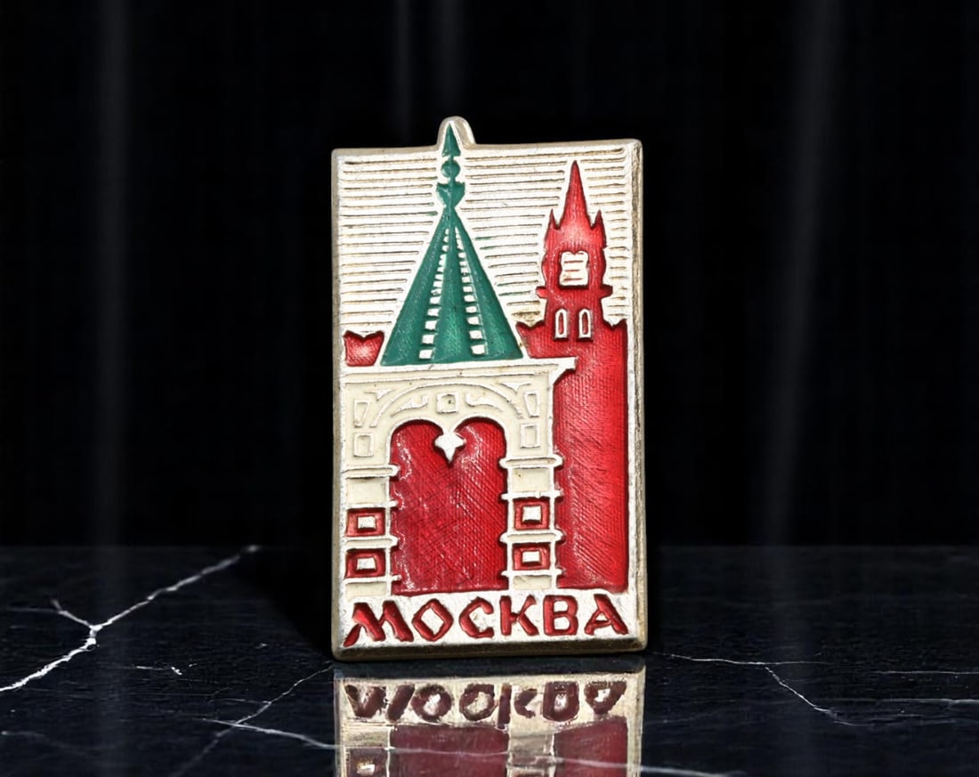 USSR: Moscow Landmarks - Kremlin Gate and Tower Enamel Badge, ca. 1960s-1970s, 31x17mm: This charming Soviet-era souvenir badge captures the architectural essence of Moscow, featuring the distinctive silhouette of a Kremlin gate and tower in bold red and green enamel. The rectangular for