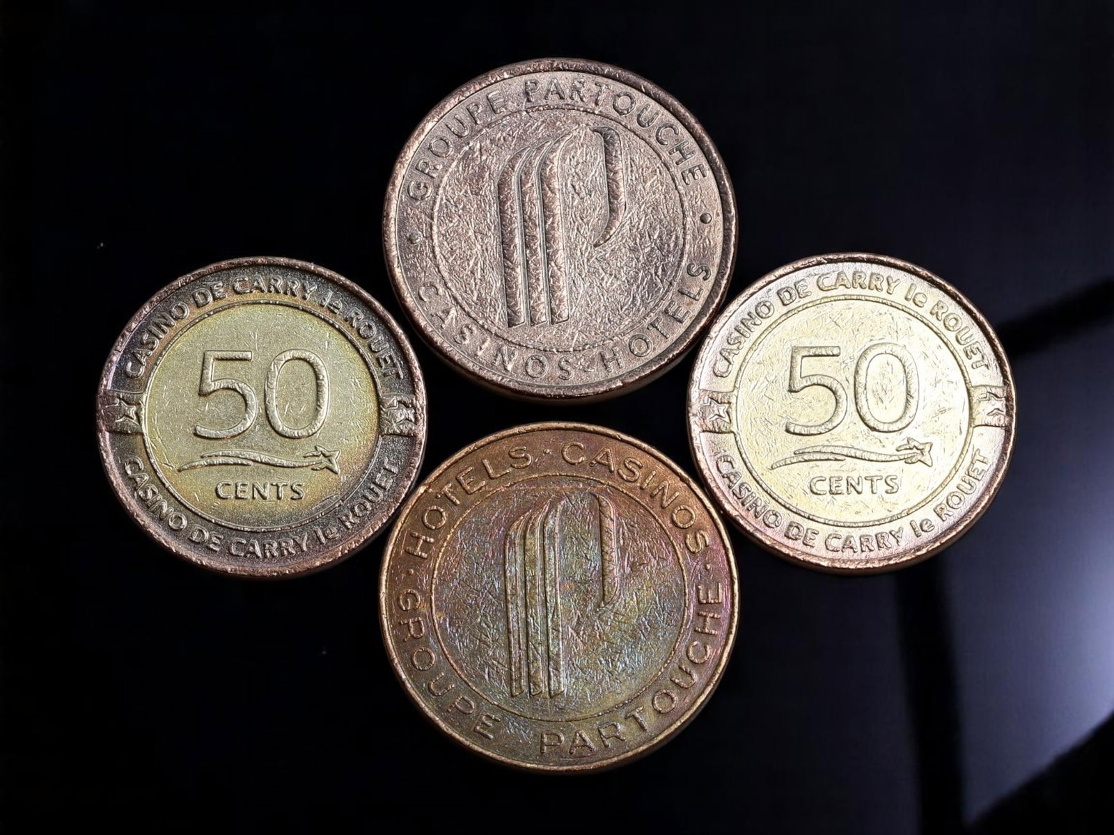 FRANCE: Riviera Elegance - Groupe Partouche & Casino de Carry-le-Rouet Gaming Tokens Lot, 23-25mm: This evocative lot of four French casino gaming tokens vividly captures the glamorous leisure culture of the French Riviera. Representing prestigious establishments from the Groupe Partouche and the C