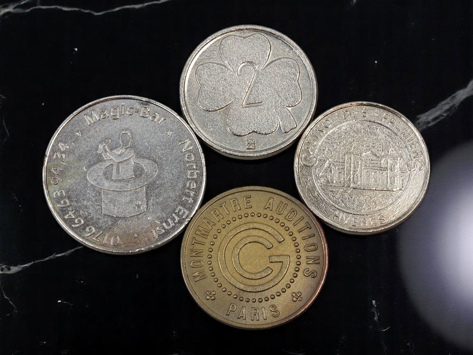 FRANCE/GERMANY: Amusement & Casino Tokens Lot (4 pcs), Montmartre, Hyeres, Magic-Bar, 25-30mm: A fascinating quartet of late 20th-century amusement and casino tokens from France and Germany, these pieces offer a glimpse into the vibrant worlds of European entertainment and leisure. Included are