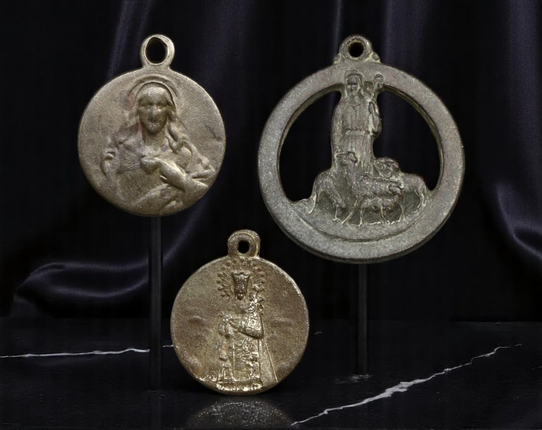 USA/SPAIN: Christian Medallion Trio Featuring Sacred Heart and Good Shepherd, 1950s-1970s, 19-28mm: This compelling trio of religious medallions bridges Catholic tradition with mid-century evangelical messaging, forming a unified declaration of faith. The largest piece, featuring an openwork silhoue